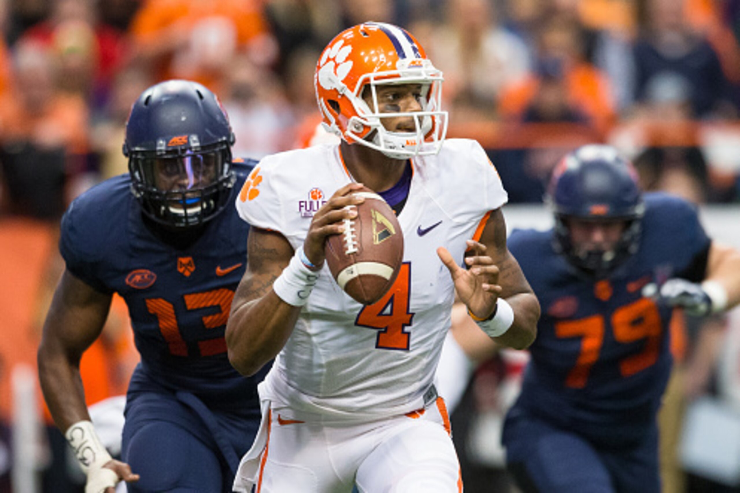 SYRACUSE, NY - NOVEMBER 14:  Deshaun Watson #4 of the Clemson Tigers scrambles as Syracuse Orange defenders pursue on November 14, 2015 at The Carrier Dome in Syracuse, New York.  Clemson defeats Syracuse 37-27.  (Photo by Brett Carlsen/Getty Images)