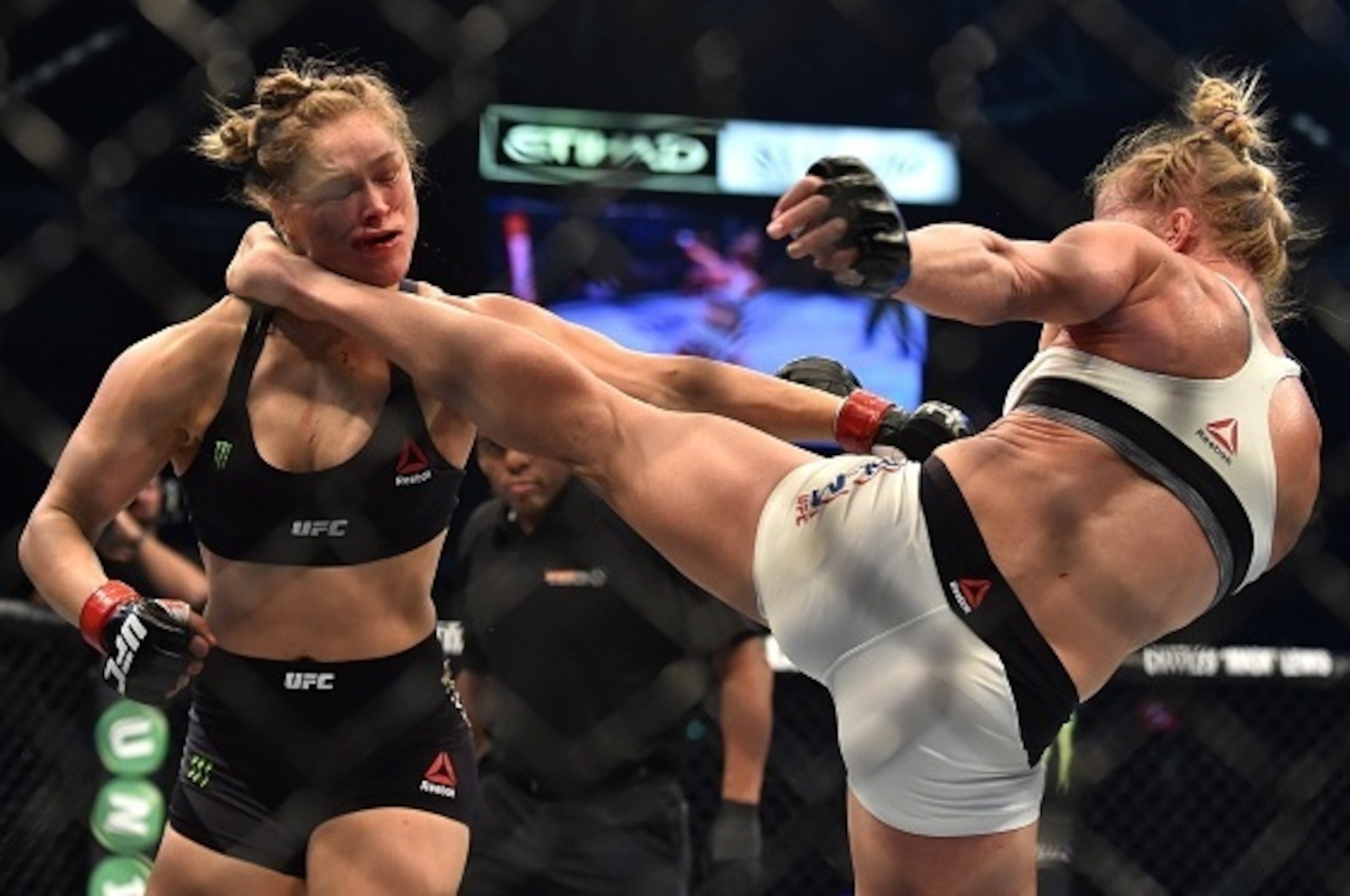 Holly Holm of the US (R) lands a kick to the neck to knock out compatriot Ronda Rousey and win the UFC title fight in Melbourne on November 15, 2015.   RESTRICTED TO EDITORIAL USE NO ADVERTISING USE NO PROMOTIONAL USE NO MERCHANDISING USE.  AFP PHOTO/Paul