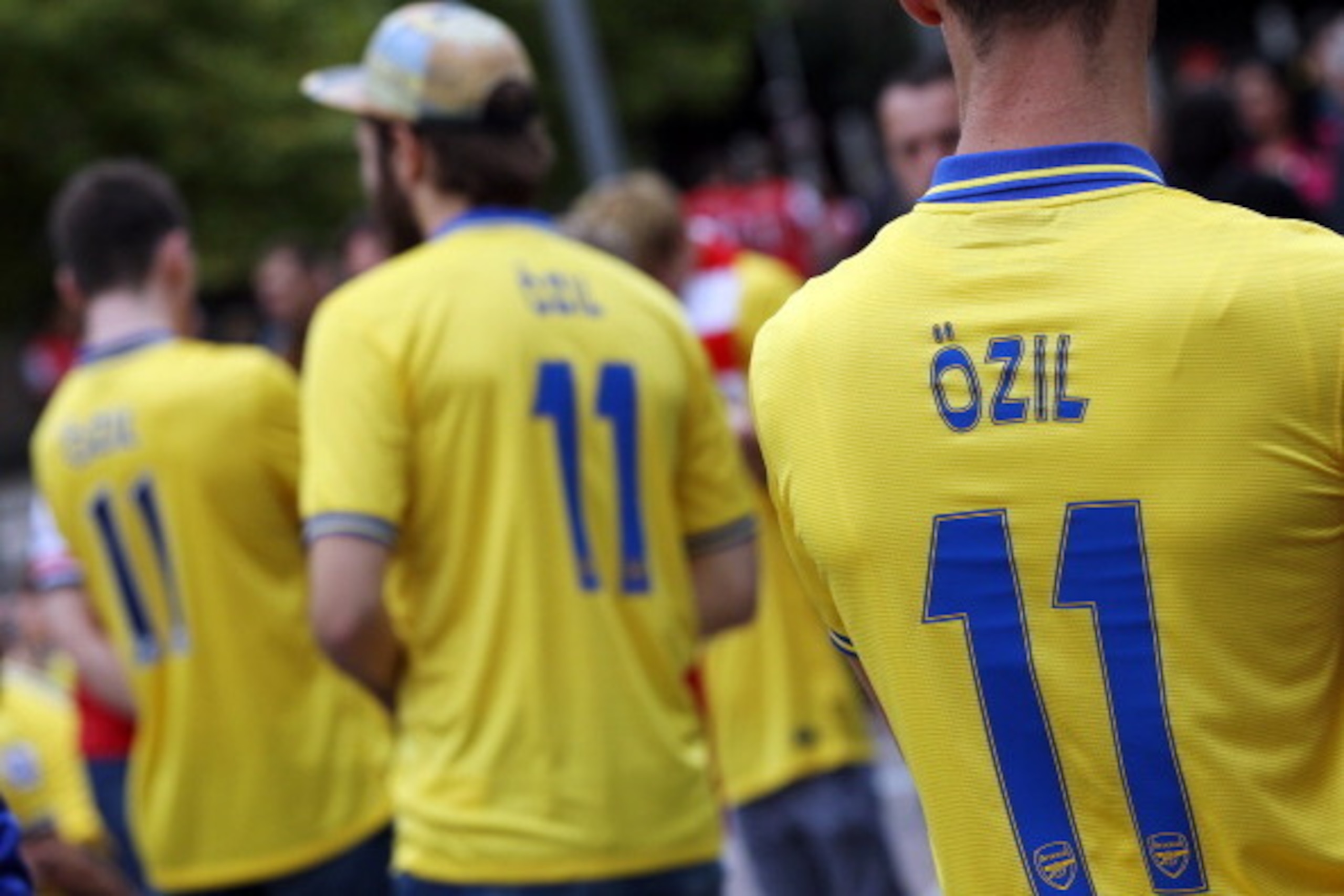 Arsenal fans wearing the No 11 shirt of new signing Arsenal's German midfielder Mesut Ozil gather outside the stadium ahead of the English Premier League football match between Arsenal and Stoke City at the Emirates stadium in north London on September 22