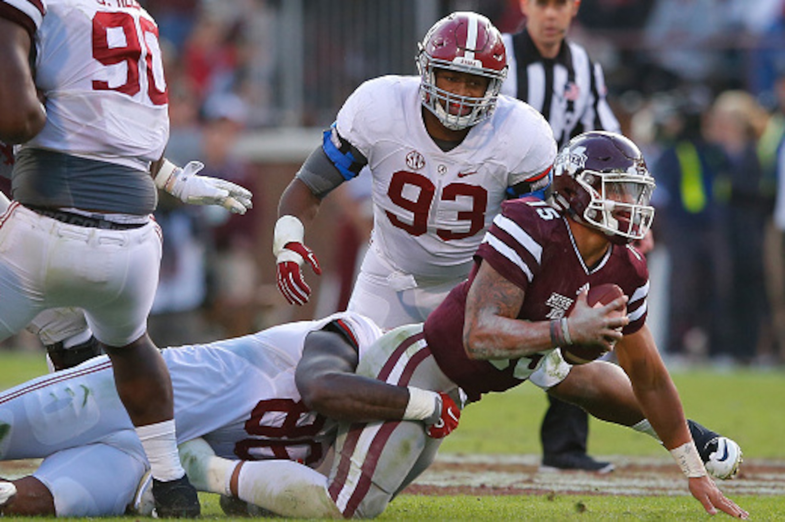 STARKVILLE, MS - NOVEMBER 14:  Dak Prescott #15 of the Mississippi State Bulldogs is tackled by A'Shawn Robinson #86 and Jonathan Allen #93 of the Alabama Crimson Tide at Davis Wade Stadium on November 14, 2015 in Starkville, Mississippi.  (Photo by Kevin