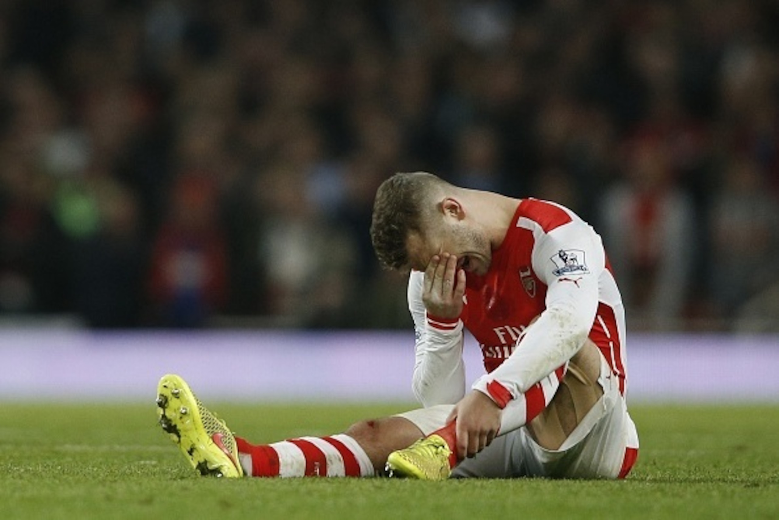 Arsenal's English midfielder Jack Wilshere lies injured during the English Premier League football match between Arsenal and Manchester United at the Emirates Stadium in London on November 22, 2014. AFP PHOTO/ADRIAN DENNIS

RESTRICTED TO EDITORIAL USE. NO