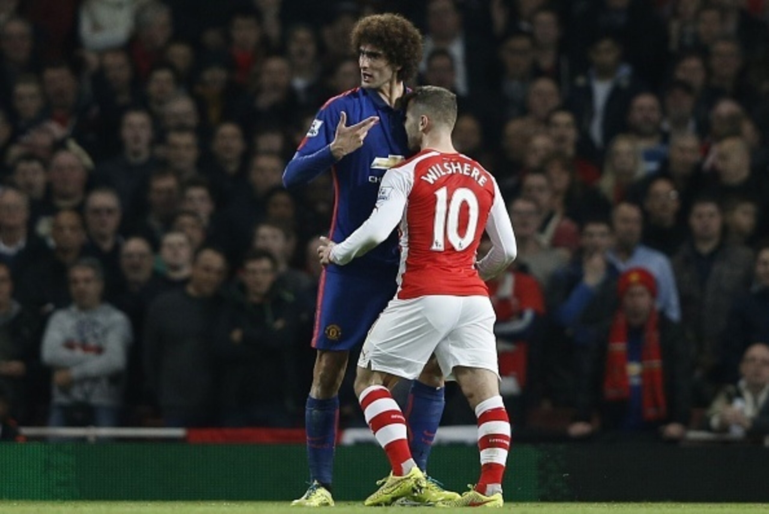 Manchester United's Belgian midfielder Marouane Fellaini (L) clashes with Arsenal's English midfielder Jack Wilshere during the English Premier League football match between Arsenal and Manchester United at the Emirates Stadium in London on November 22, 2