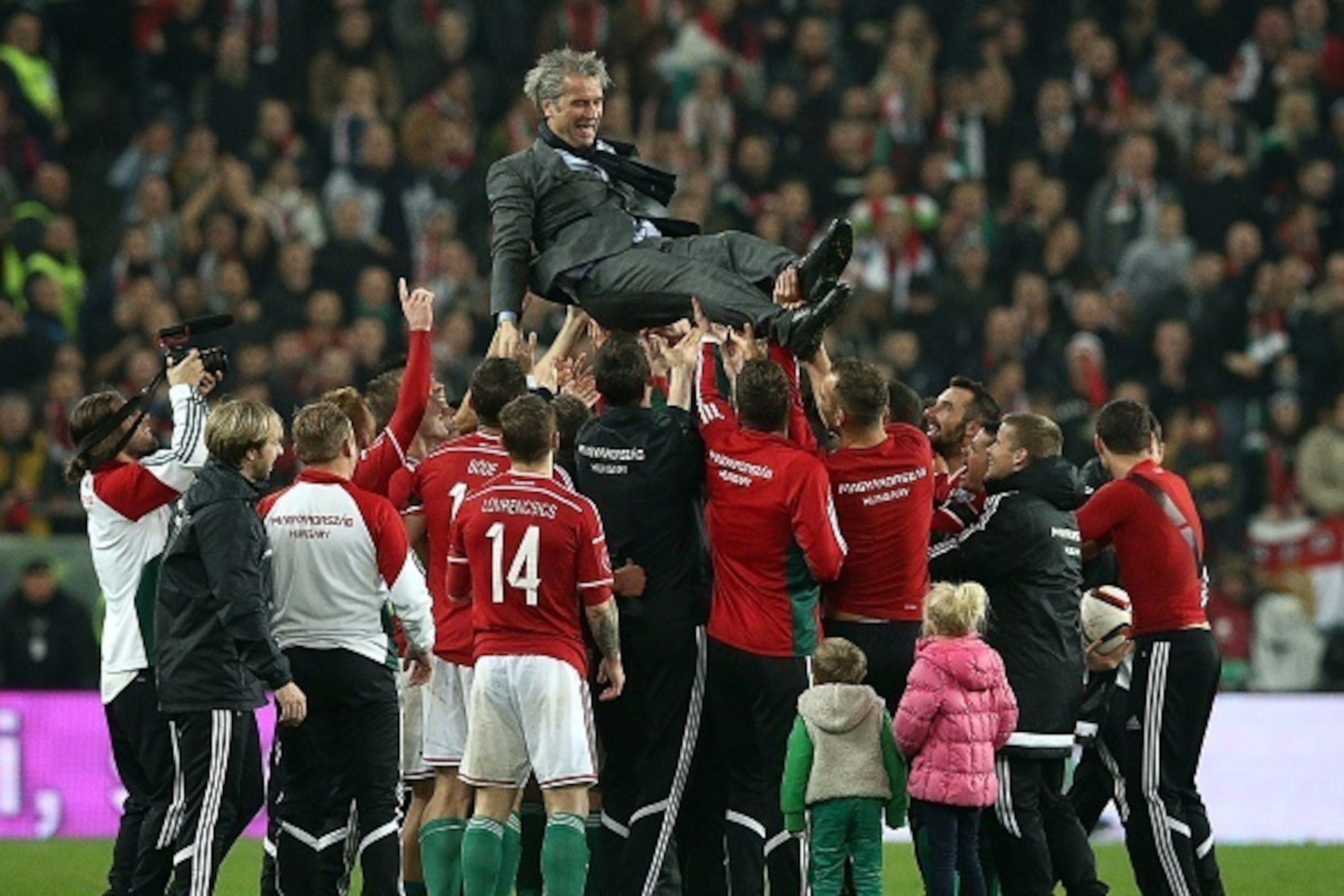 Hungary's players celebrate with their coach Bernd Storck (c) after they win during the Euro 2016 play-off football match between Norway and Hungary at the Grupama Arena in Budapest on November 15, 2015. Hungary won 2-1 and on aggregate 3-1 and qualified 