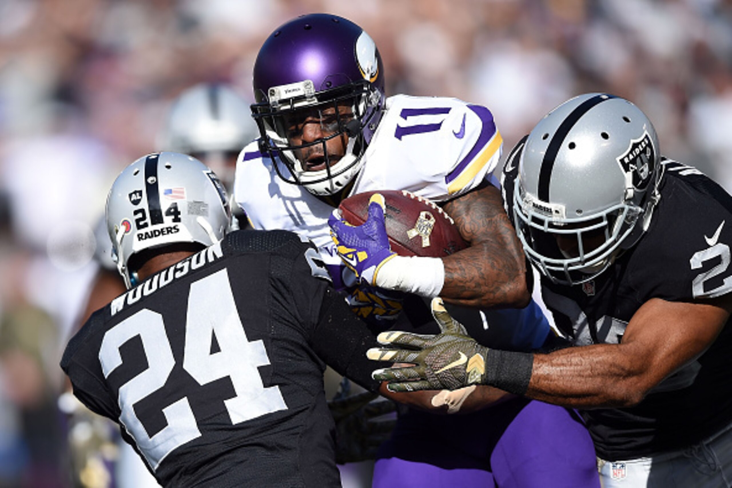 OAKLAND, CA - NOVEMBER 15:  Wide receiver Mike Wallace #11 of the Minnesota Vikings is stopped by free safety Charles Woodson #24 of the Oakland Raiders and strong safety Nate Allen #20 of the Oakland Raiders in the first quarter at O.co Coliseum on Novem