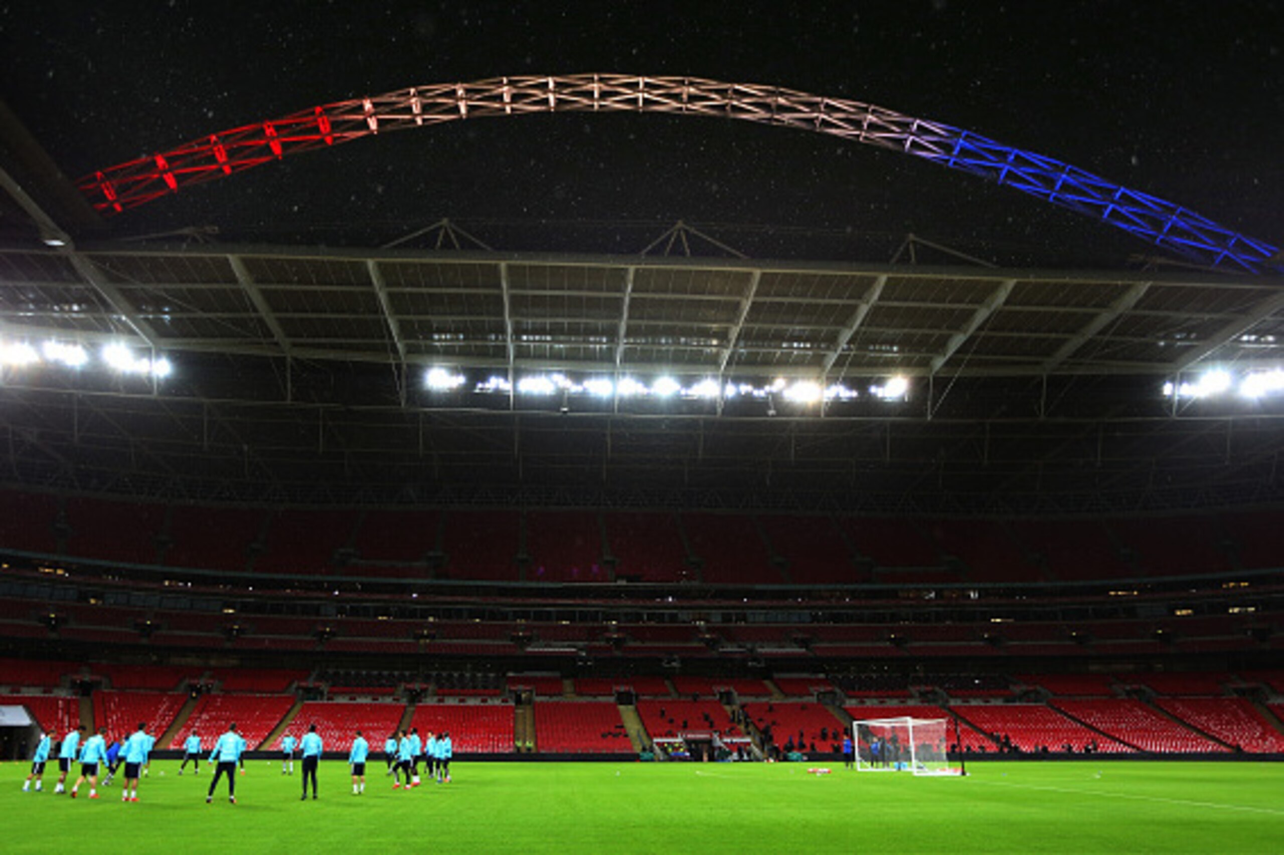 LONDON, ENGLAND - NOVEMBER 16:  The French players run through their drills under the Wembley arch, lit up in the colours of the French Tricolore during the France training session at Wembley Stadium on November 16, 2015 in London, England.  (Photo by Poo