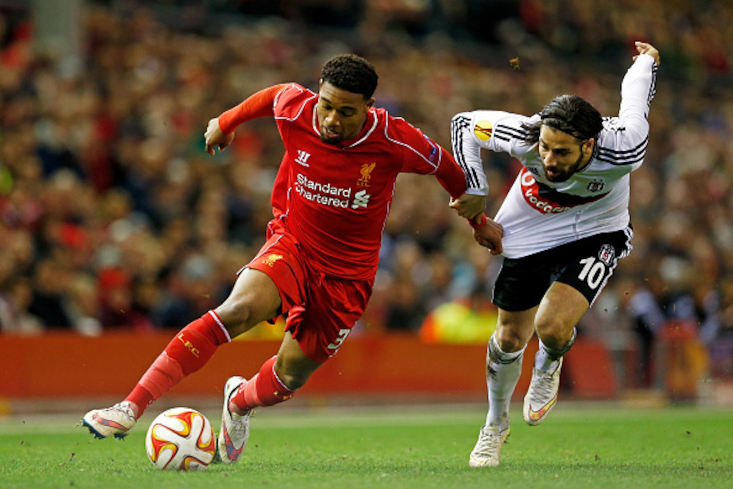 LIVERPOOL, ENGLAND - FEBRUARY 19:  Jordon Ibe of Liverpool goes past Olcay Sahan of Besiktas during the UEFA Europa League Round of 32 match between Liverpool FC and Besiktas JK at Anfield on February 19, 2015 in Liverpool, United Kingdom.  (Photo by Juli