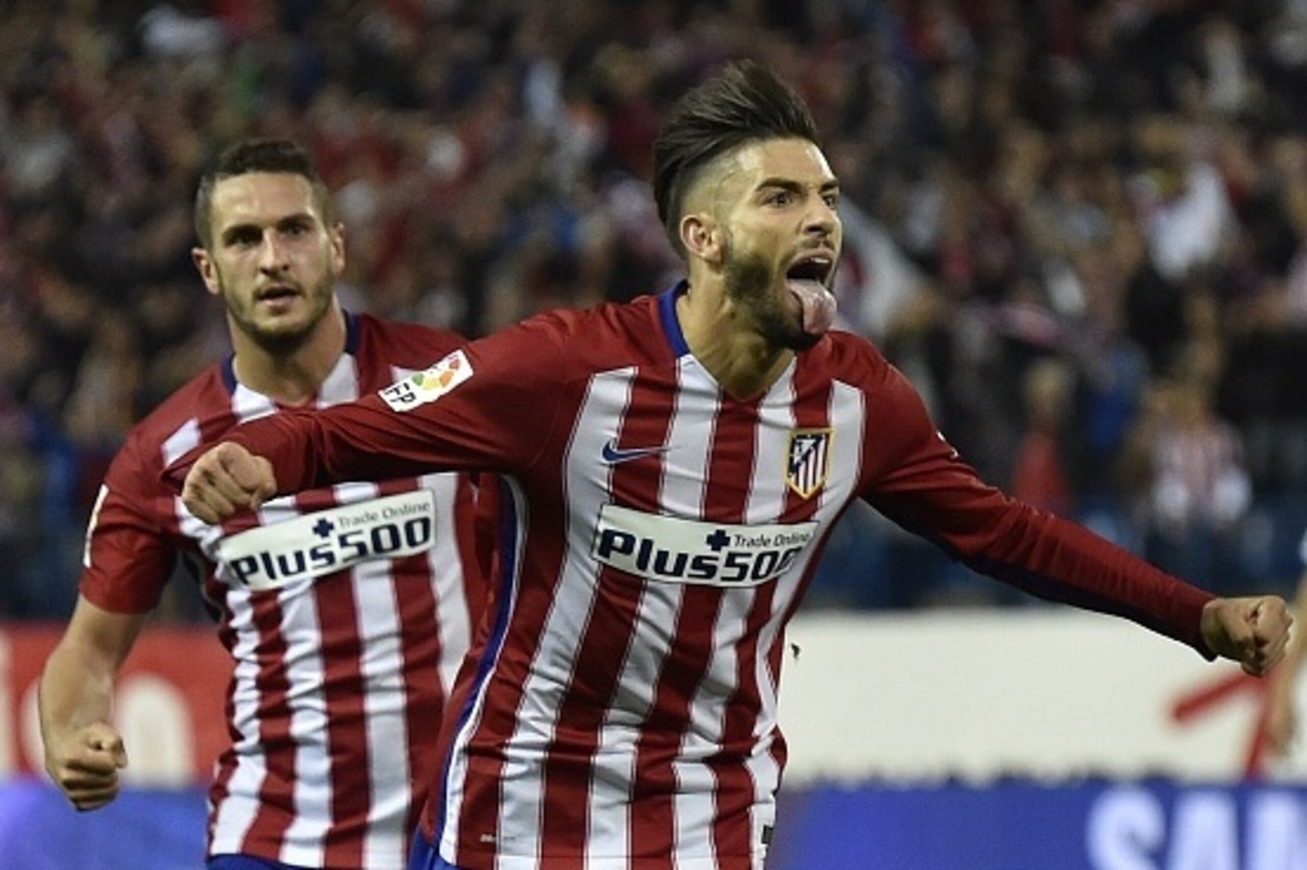 Atletico Madrid's Belgian midfielder Yannick Ferreira Carrasco (R) gestures as he celebrates a goal next to Atletico Madrid's midfielder Koke during the Spanish league football match Club Atletico de Madrid vs Valencia CF at the Vicente Calderon stadium i