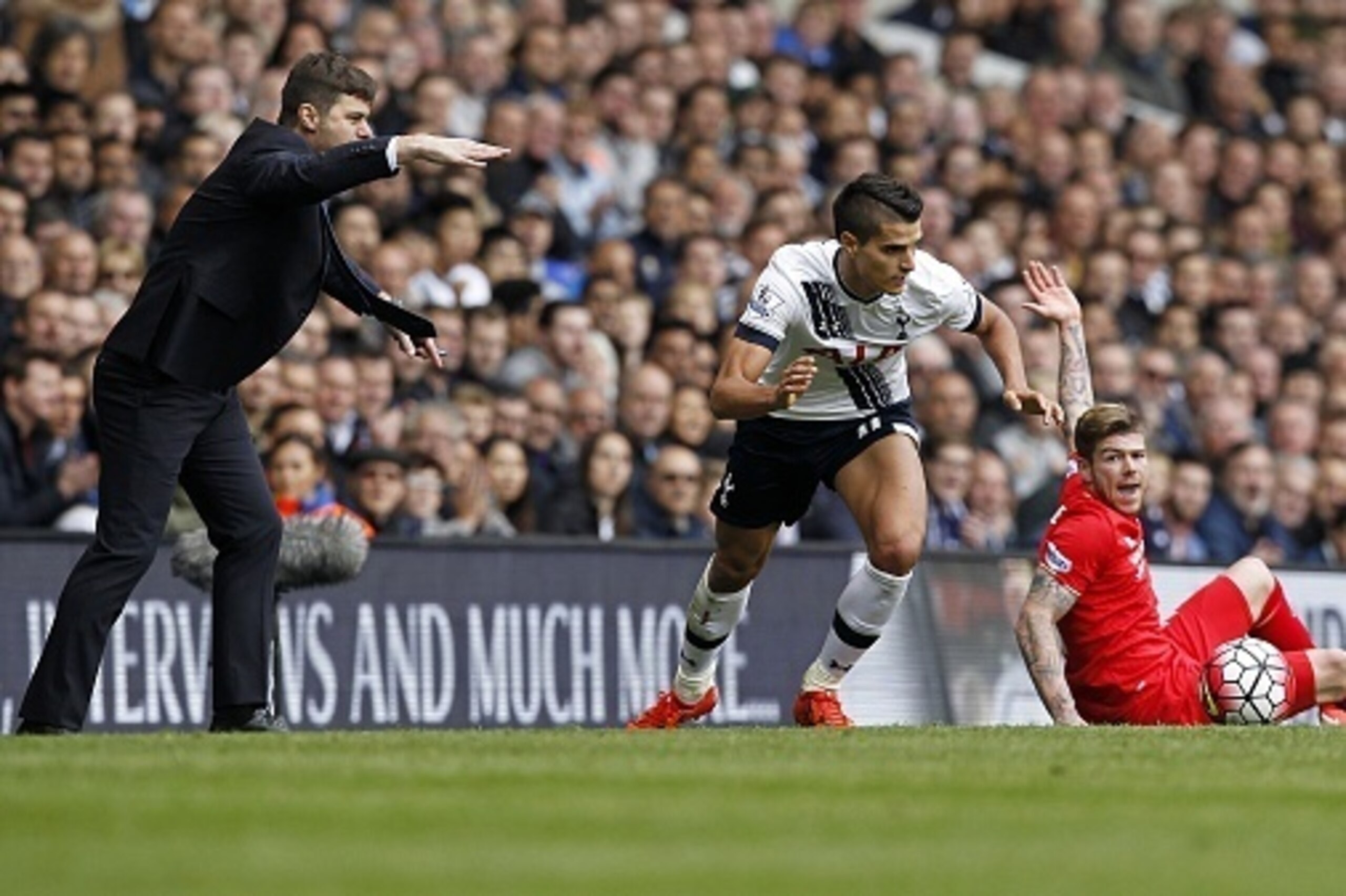 Tottenham Hotspur's Argentinian Head Coach Mauricio Pochettino (L) gestures as Tottenham Hotspur's Argentinian midfielder Erik Lamela runs away from Liverpool's Spanish defender Alberto Moreno (R) during the English Premier League football match between T