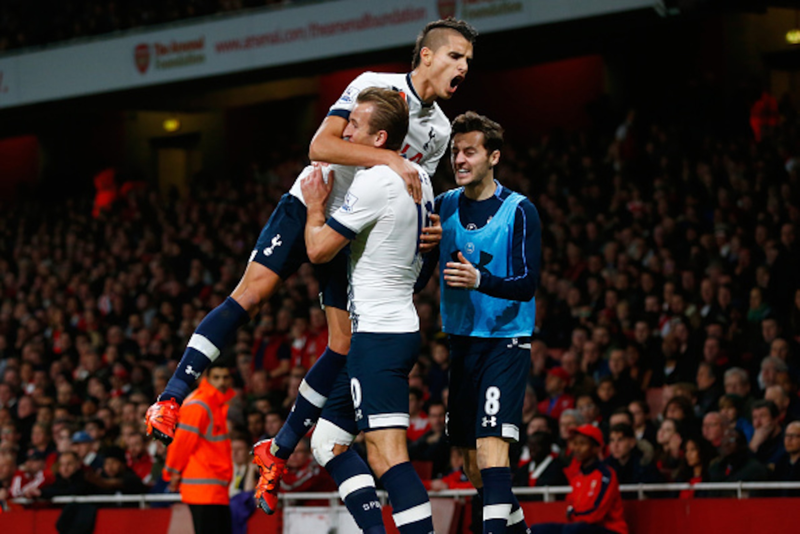 LONDON, ENGLAND - NOVEMBER 08:  Harry Kane of Spurs celebrates scoring his side's opening goal with Erik Lamela of Spurs (L) and Ryan Mason of Spurs during the Barclays Premier League match between Arsenal and Tottenham Hotspur at the Emirates Stadium on 