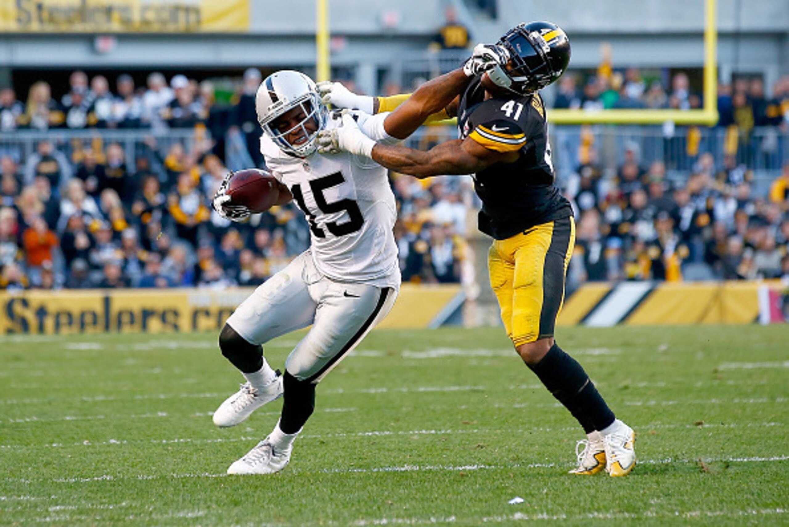 PITTSBURGH, PA - NOVEMBER 08:  Michael Crabtree #15 of the Oakland Raiders stiff arms Antwon Blake #41 of the Pittsburgh Steelers after catching a pass in the 4th quarter of the game at Heinz Field on November 8, 2015 in Pittsburgh, Pennsylvania.  (Photo 