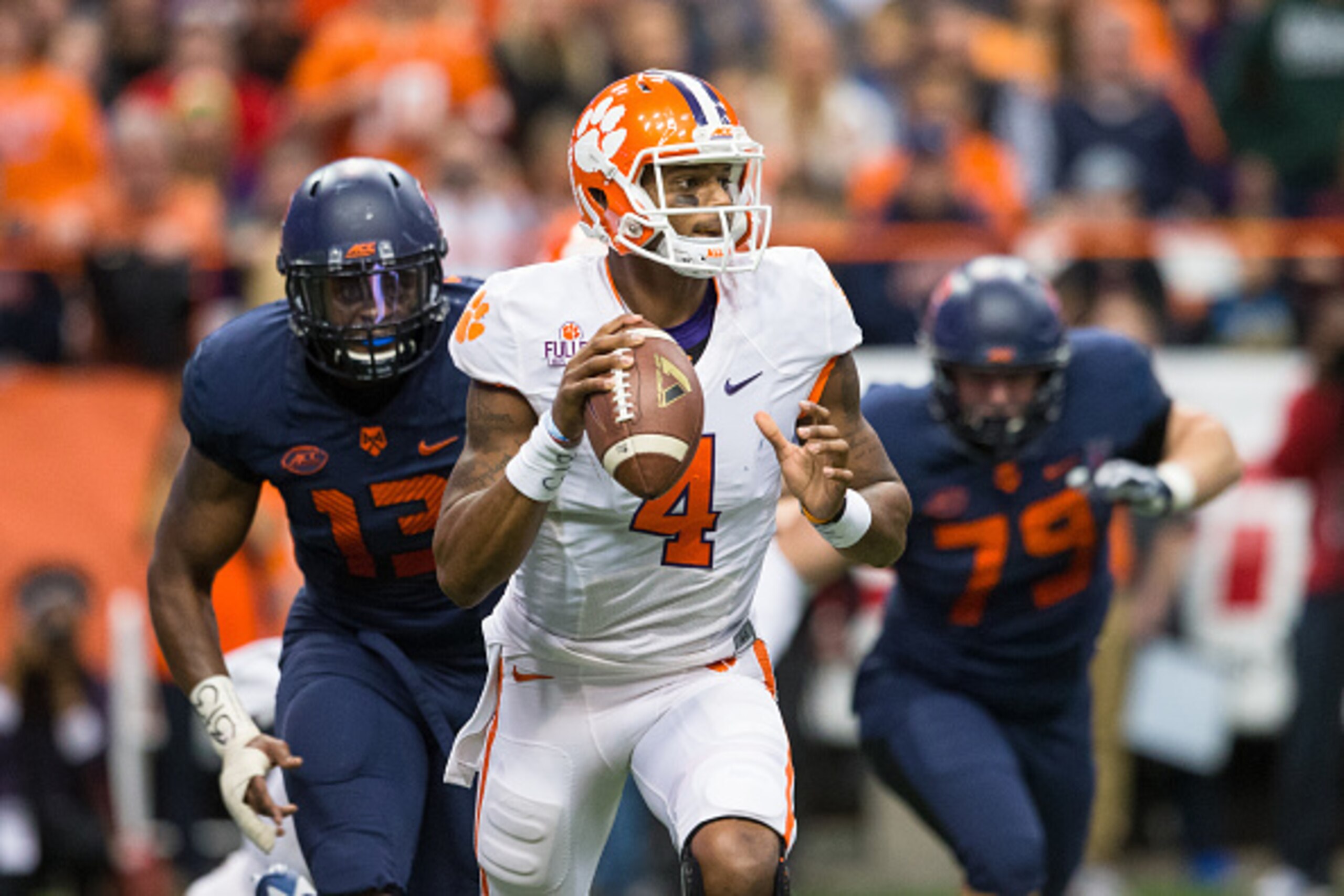 SYRACUSE, NY - NOVEMBER 14:  Deshaun Watson #4 of the Clemson Tigers scrambles as Syracuse Orange defenders pursue on November 14, 2015 at The Carrier Dome in Syracuse, New York.  Clemson defeats Syracuse 37-27.  (Photo by Brett Carlsen/Getty Images)