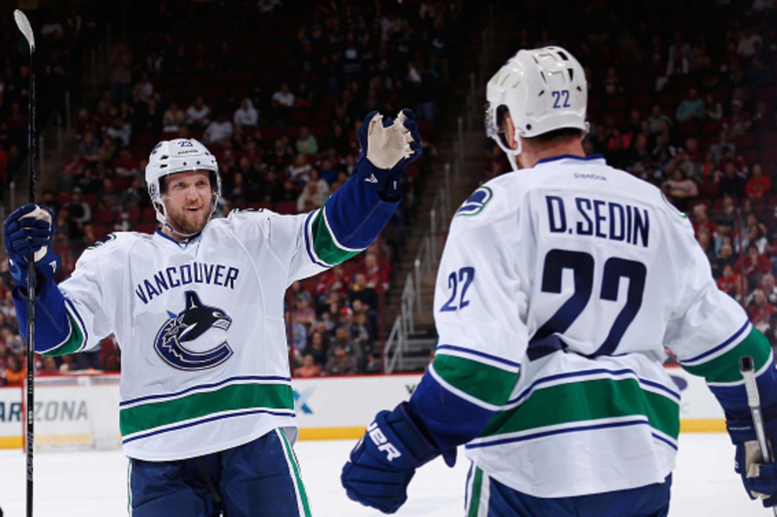 GLENDALE, AZ - OCTOBER 30:  Alexander Edler #23 of the Vancouver Canucks celebrates with Daniel Sedin #22 after Sedin scored a second period power play goal against the Arizona Coyotes during the NHL game at Gila River Arena on October 30, 2015 in Glendal