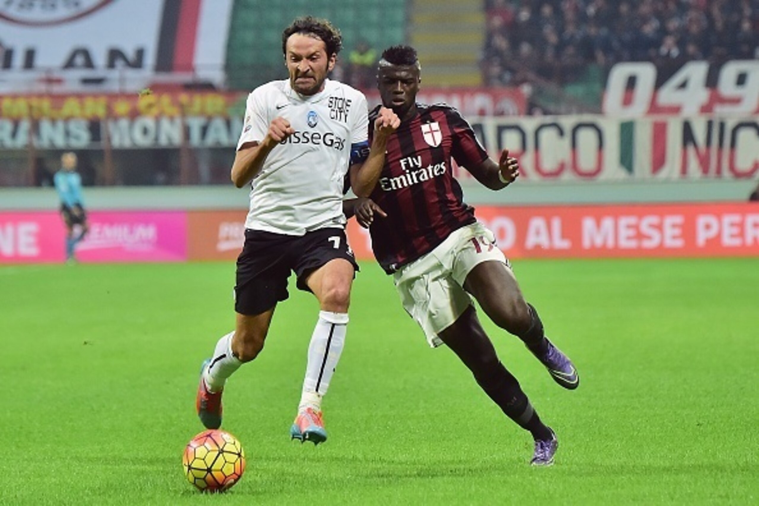 Atalanta's Italian midfielder Cristian Raimondi (L) challenges AC Milan's French forward Mbaye Niang during the Serie A football match between AC Milan and Atalanta at the San Siro Stadium in Milan on November 7, 2015. AFP PHOTO / GIUSEPPE CACACE
        