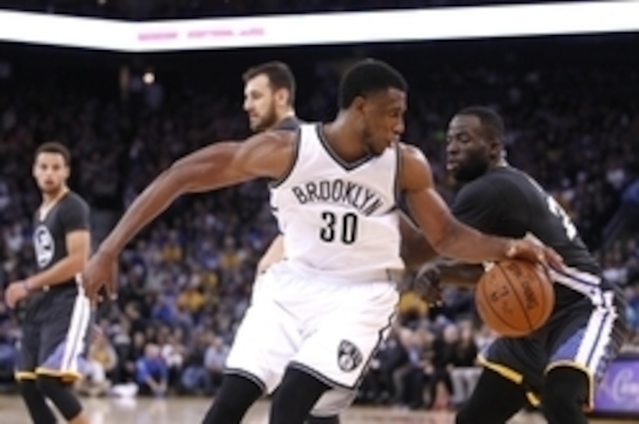 Nov 14, 2015; Oakland, CA, USA; Brooklyn Nets forward Thaddeus Young (30) spins towards the hoop next to Golden State Warriors forward Draymond Green (23) in the third quarter at Oracle Arena. The Warriors defeated the Nets 107-99 in overtime. Mandatory C