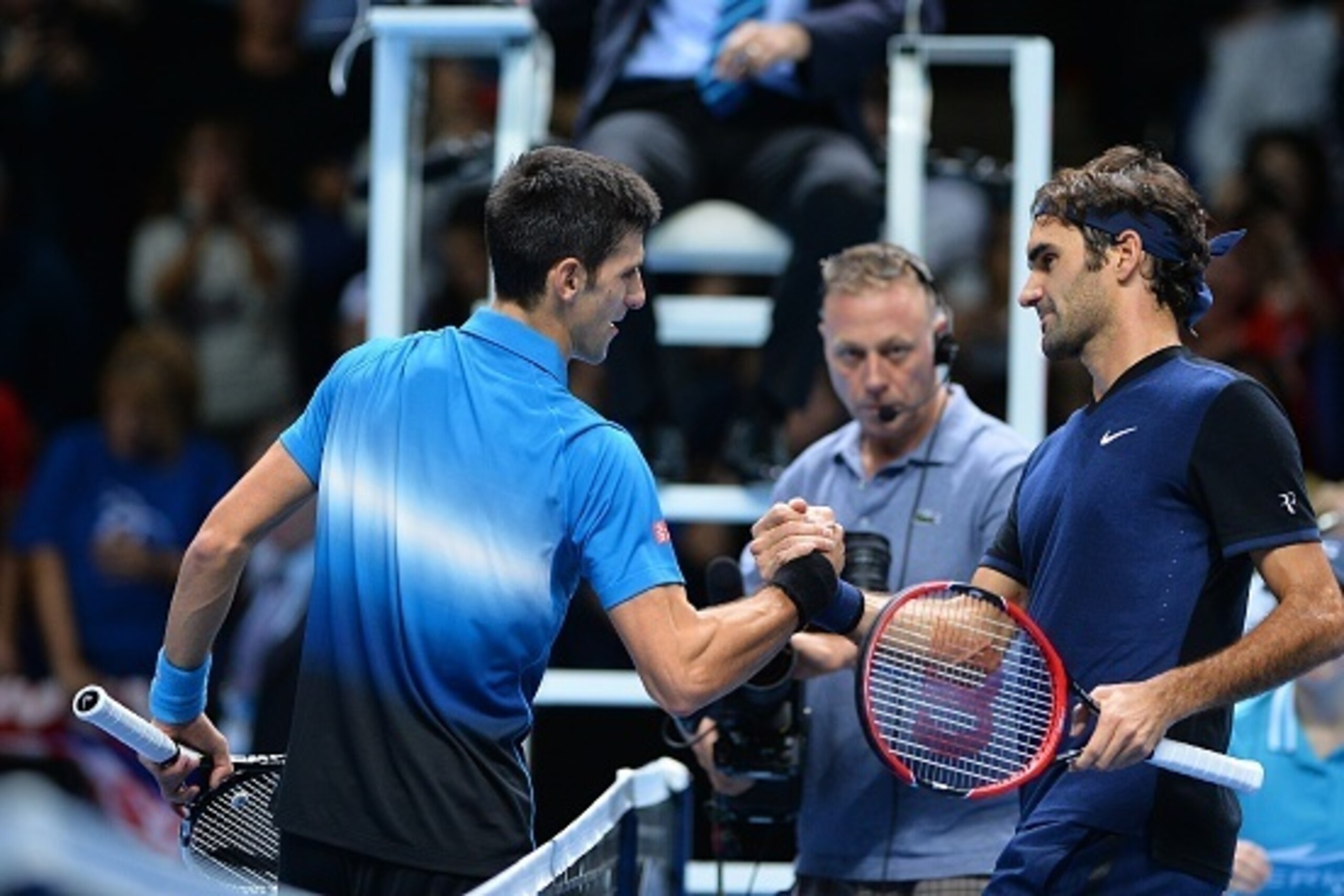 Switzerland's Roger Federer (R) shakes hands with Serbia's Novak Djokovic after winning his men's singles group stage match on day three of the ATP World Tour Finals tennis tournament in London on November 17, 2015. Federer won the match 7-5, 6-2.   AFP P
