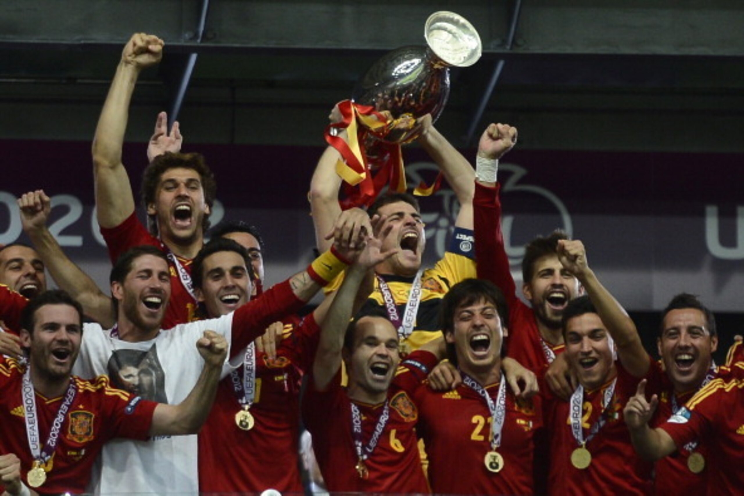 Spanish players celebrate with the trophy after the Euro 2012 football championships final match Spain vs Italy on July 1, 2012 at the Olympic Stadium in Kiev.       AFP PHOTO / FILIPPO MONTEFORTE        (Photo credit should read FILIPPO MONTEFORTE/AFP/Ge