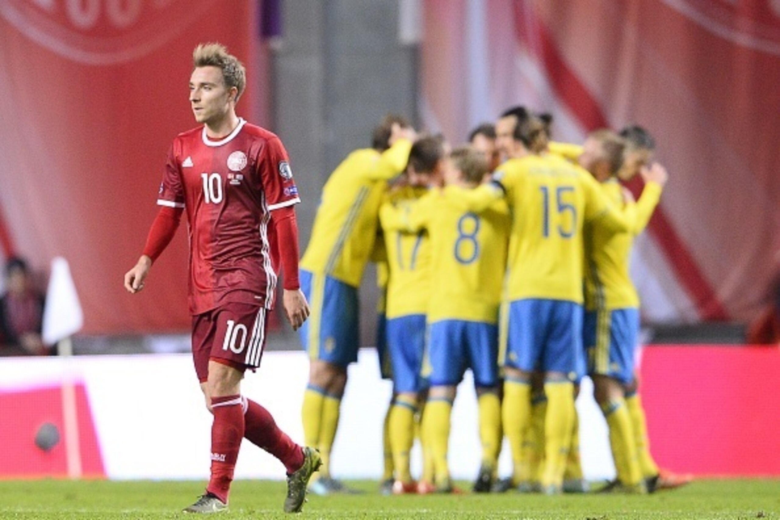 Denmark's midfielder Christian Eriksen (L) reacts as Sweden's forward and team captain Zlatan Ibrahimovic (C) celebartes with teammates after scoring a goal during the Euro 2016 second leg play-off football match between Denmark and Sweden at Parken stadi