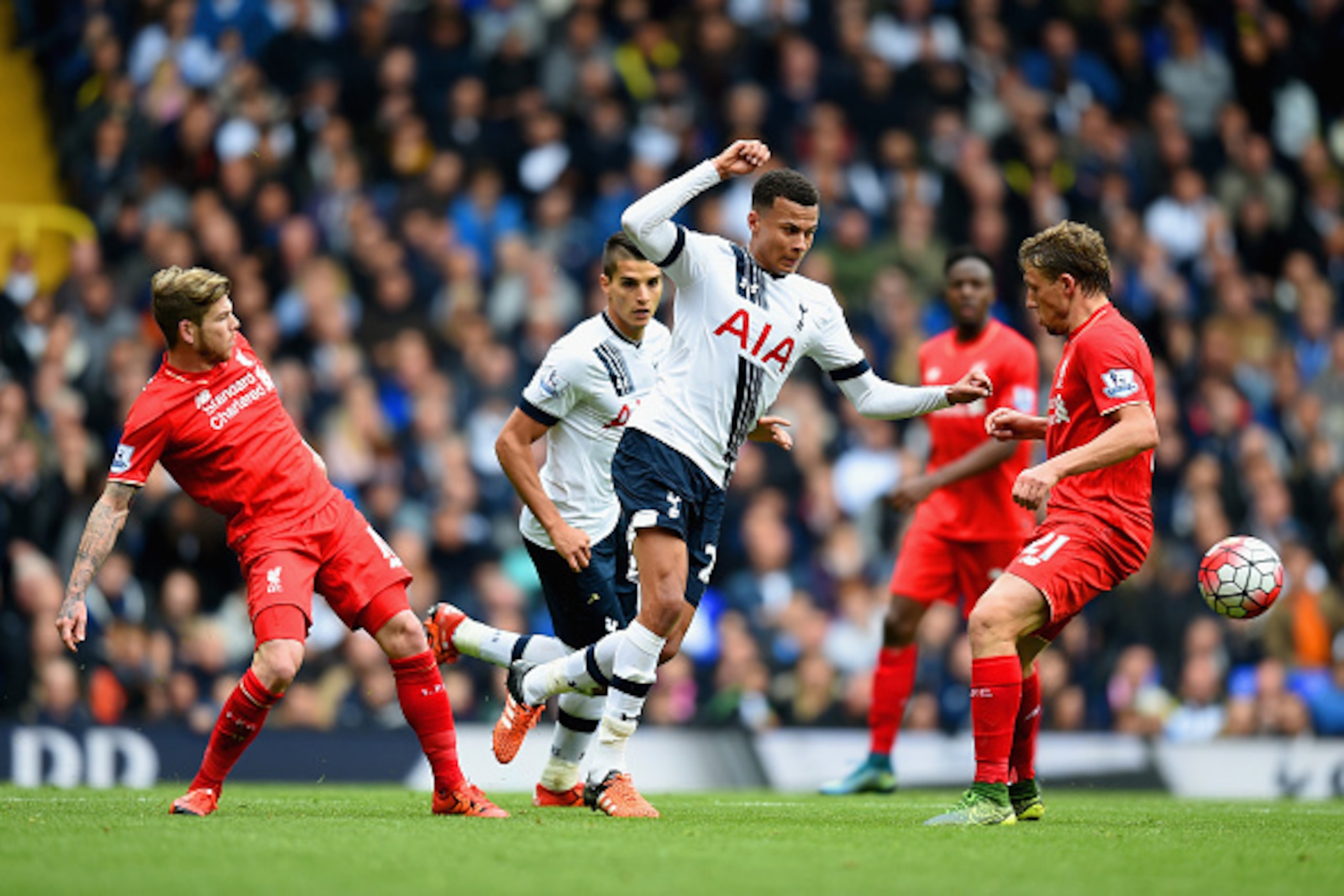 LONDON, ENGLAND - OCTOBER 17: Dele Alli (C) of Tottenham Hotspur competes for the ball against Alberto Moreno (L) and Lucas Leiva (R) of Liverpool  during the Barclays Premier League match between Tottenham Hotspur and Liverpool at White Hart Lane on Octo