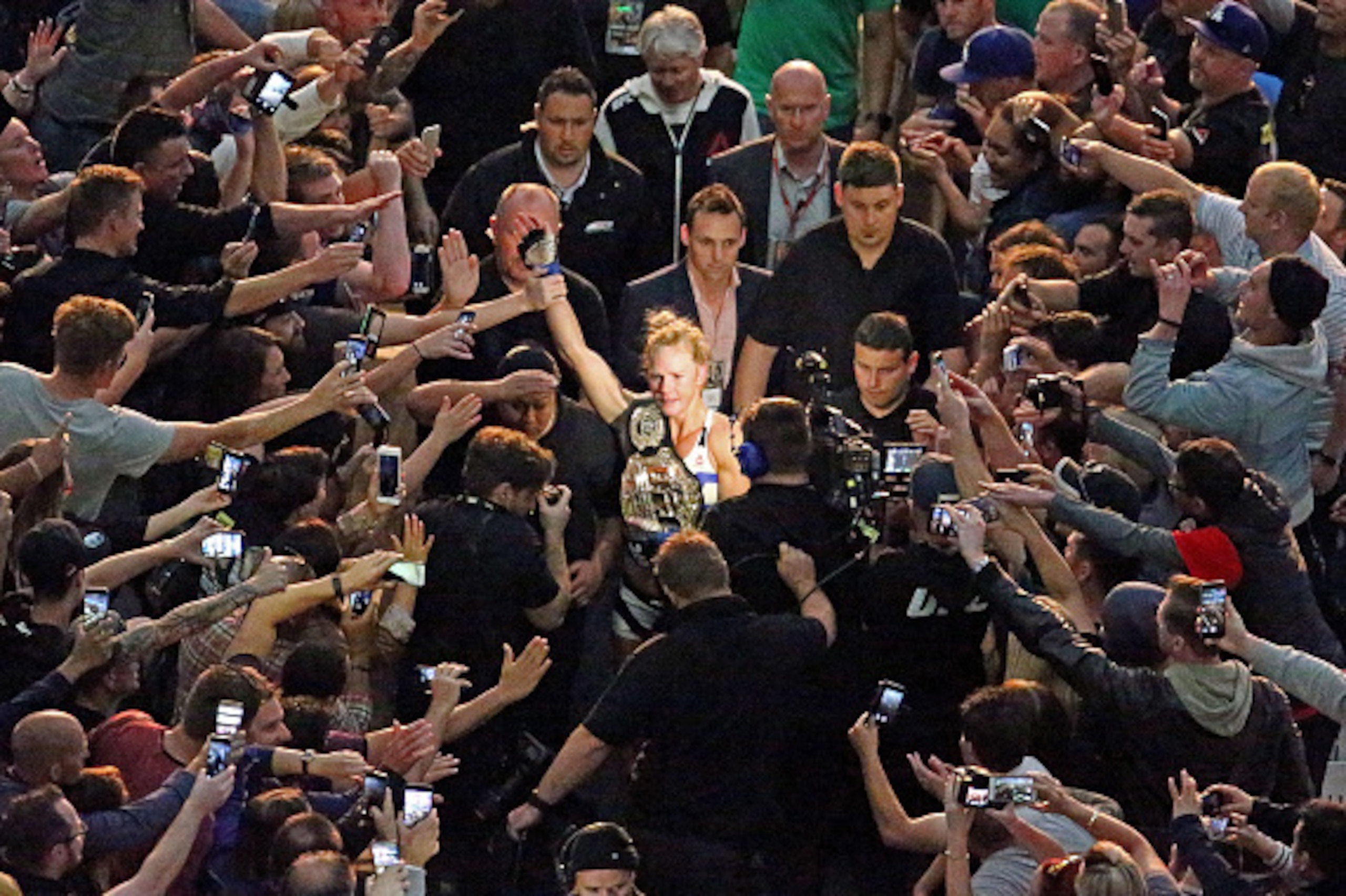 MELBOURNE, AUSTRALIA - NOVEMBER 15:  New UFC women's bantamweight champion Holly Holm (C) of the United States celebrates as she makes her way through the crowd as she leaves the arena after her victory over Ronda Rousey of the United States in their UFC 