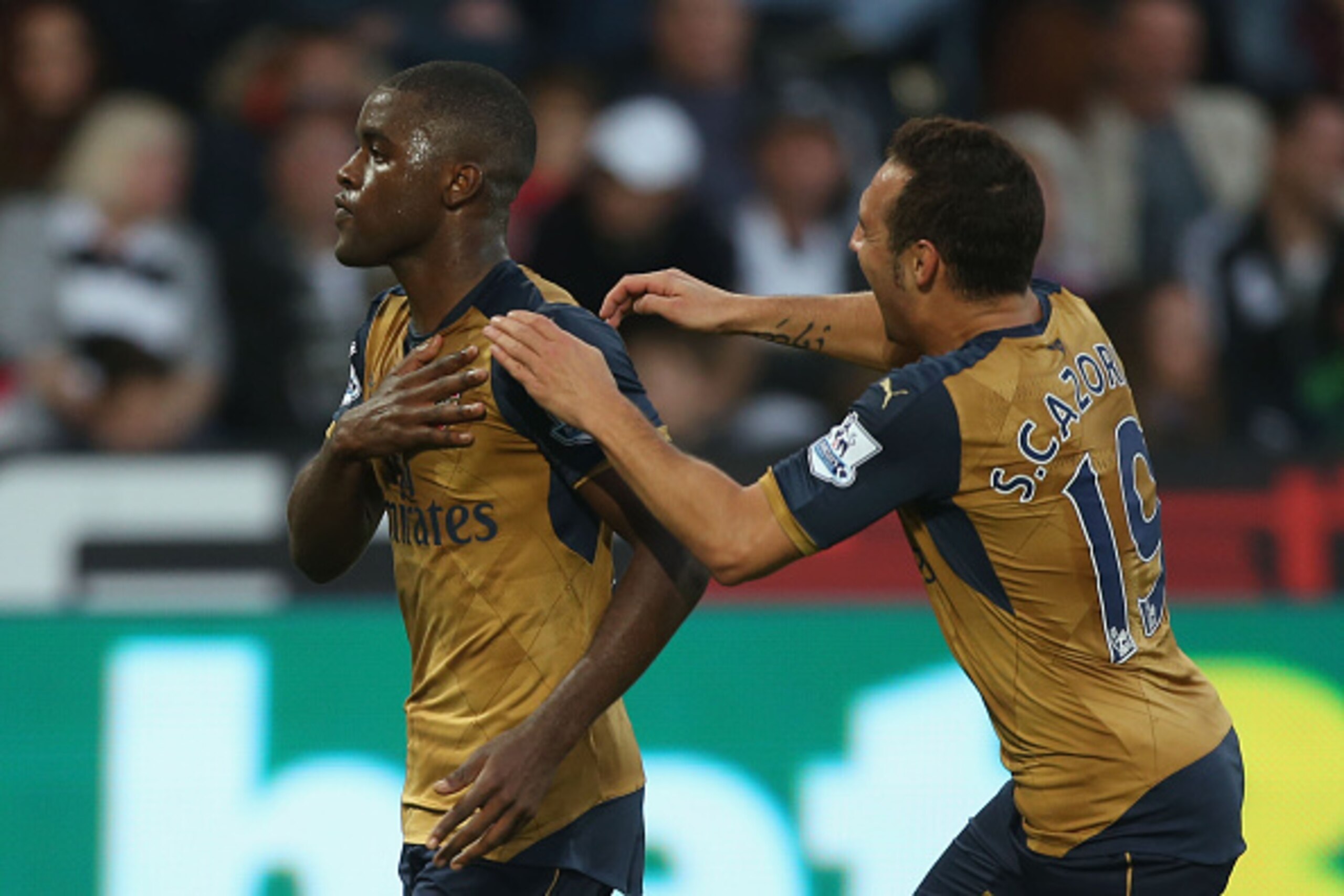 SWANSEA, WALES - OCTOBER 31:  Joel Campbell (L) of Arsenal celebrates scoring his team's third goal with his team mate Santi Cazorla (R) during the Barclays Premier League match between Swansea City and Arsenal at Liberty Stadium on October 31, 2015 in Sw