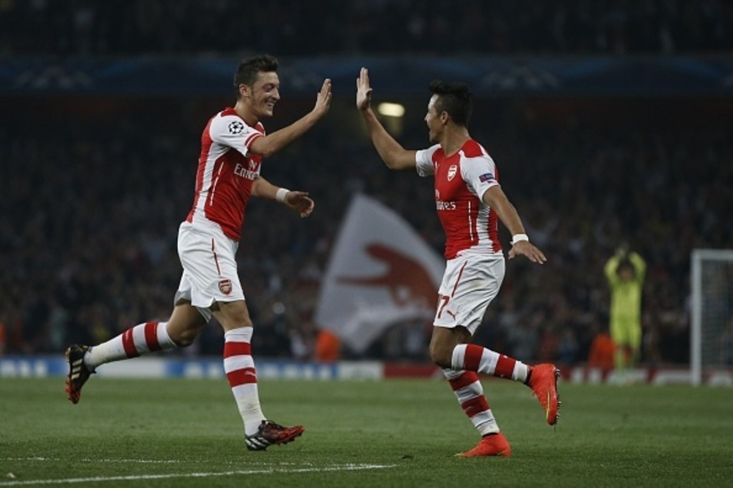 Arsenal's Chilean striker Alexis Sanchez (R) celebrates scoring his goal with Arsenal's German midfielder Mesut Ozil (L) during the UEFA Champions League, Group D football match between Arsenal and Galatasaray at The Emirates Stadium in north London on Oc