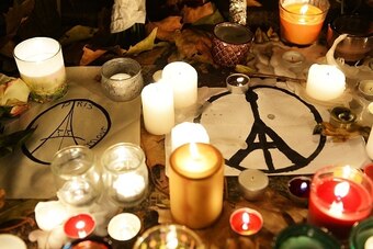 This photo taken on November 16, 2015 shows candles and messages left at a makeshift memorial next to the Bataclan concert hall in Paris. Islamic State jihadists claimed a series of coordinated attacks by gunmen and suicide bombers in Paris that killed at