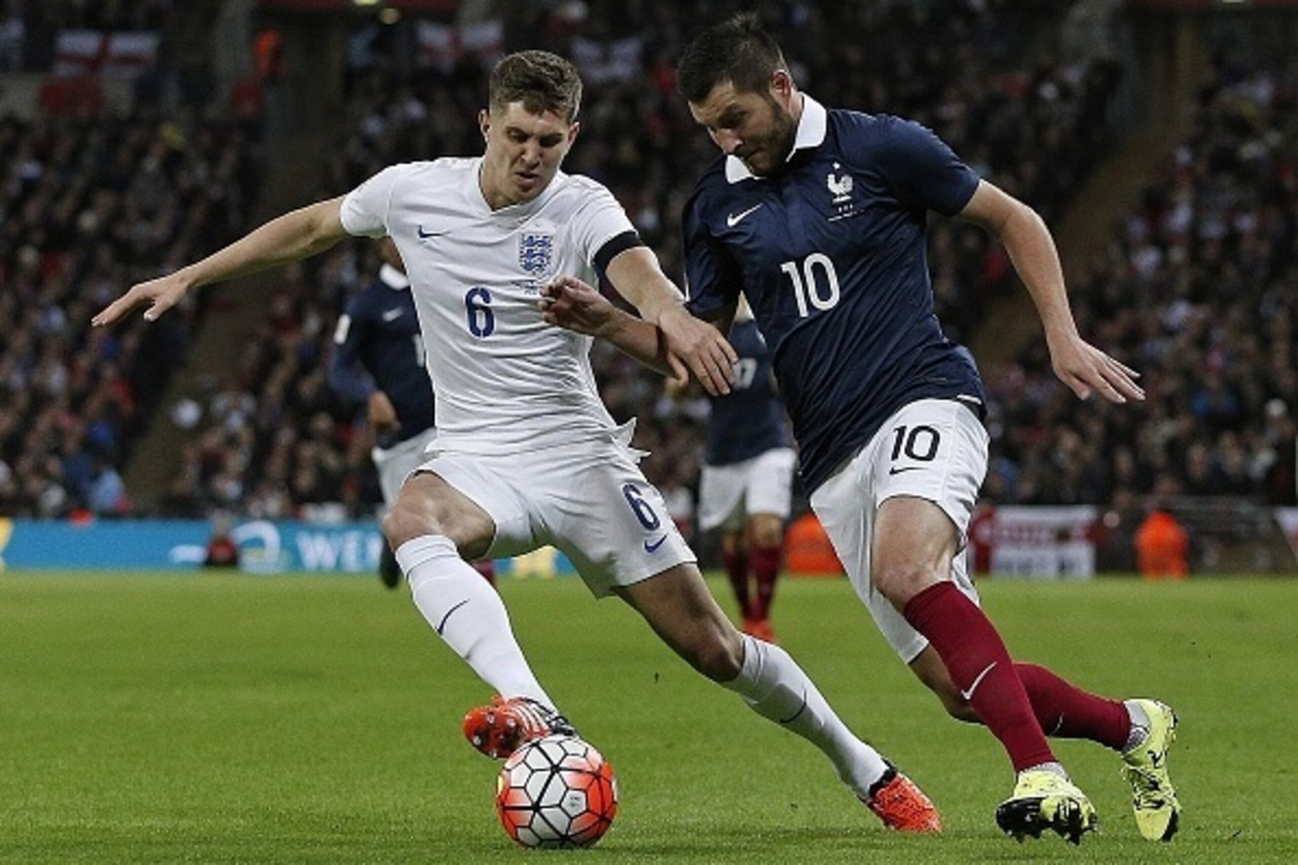 England's defender John Stones (L) vues against France's forward Andre-Pierre Gignac during the friendly football match between England and France at Wembley Stadium in west London on November 17, 2015.  England won the match 2-0.    AFP PHOTO / ADRIAN DE