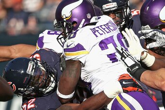 CHICAGO, IL - NOVEMBER 01: Adrian Peterson #28 of the Minnesota Vikings is tackled by LaRoy Reynolds #52 of the Chicago Bears at Soldier Field on November 1, 2015 in Chicago, Illinois. The Vikings defeated the Bears 23-20. (Photo by Jonathan Daniel/Getty 