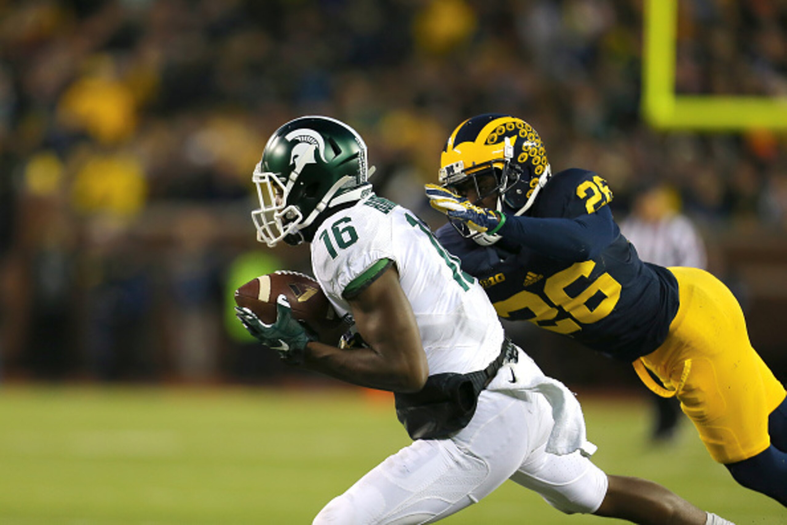 ANN ARBOR, MI - OCTOBER 17:  Aaron Burbridge #16 of the Michigan State Spartans makes a catch in the fourth quarter and tackled by Jourdan Lewis #26 of the Michigan Wolverines at Michigan Stadium on October 17, 2015 in Ann Arbor, Michigan. (Photo by Rey D