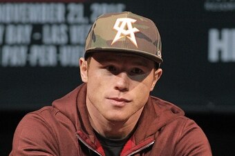Two time world champion, Saul 'Canelo' Alvarez from Guadalajara, Mexico looks on as former WBC Middleweight World Champion Miguel Cotto, from Puerto Rico speaks during a press conference in Las Vegas, Nevada on November 18, 2015.  Cotto was stripped of hi