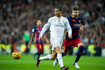 MADRID, SPAIN - NOVEMBER 21:  Cristiano Ronaldo of Real Madrid duels for the ball with Gerard Pique of Barcelona during the La Liga match between Real Madrid CF and FC Barcelona at Estadio Santiago Bernabeu on November 21, 2015 in Madrid, Spain.  (Photo b