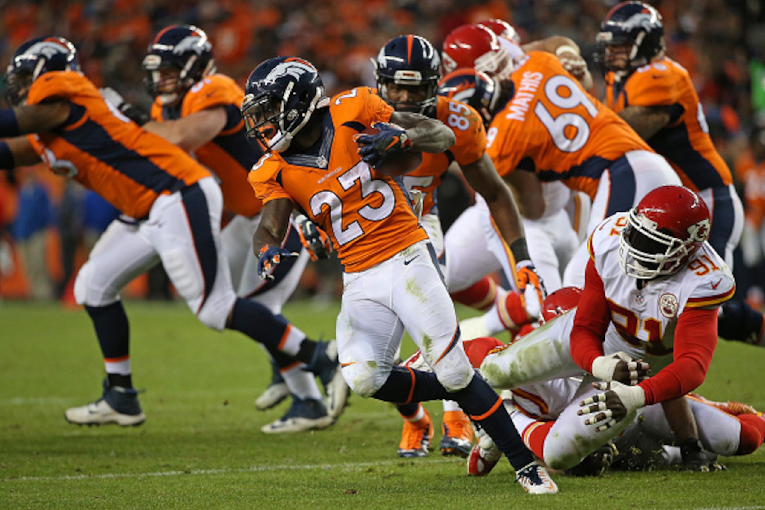 DENVER, CO - NOVEMBER 15:  Ronnie Hillman #23 of the Denver Broncos eludes Tamba Hali #91 of the Kansas City Chiefs as he carries the ball at Sports Authority Field at Mile High on November 15, 2015 in Denver, Colorado. The Chiefs defeated the Broncos 29-
