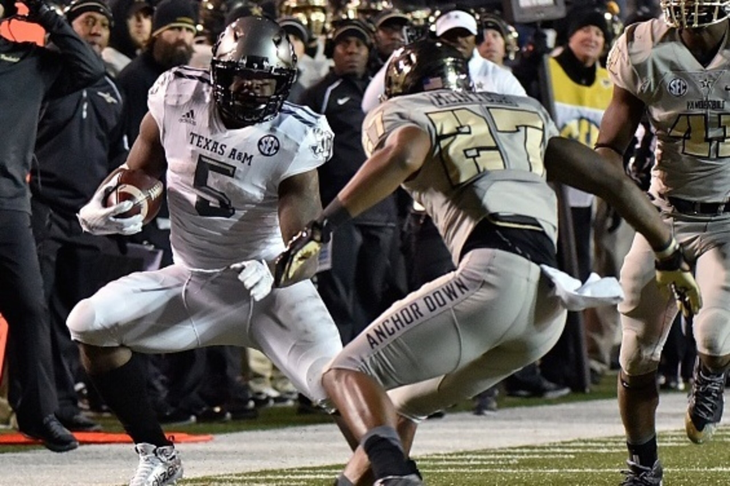 NASHVILLE, TN - NOVEMBER 21:  Running back Tra Carson #5 of the Texas A&M Aggies rushes against Jahmel McIntosh #27 of the Vanderbilt Commodores during the second half at Vanderbilt Stadium on November 21, 2015 in Nashville, Tennessee.  (Photo by Frederic