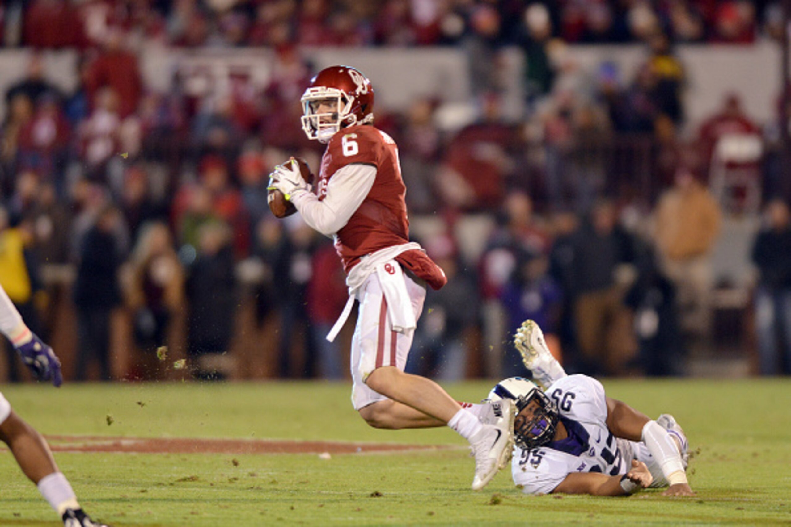NORMAN, OK - NOVEMBER 21: Quarterback Baker Mayfield #6 of the Oklahoma Sooners looks to pass during first half action under pressure from defensive tackle Aaron Curry #95 of the Texas Christian Horned Frogs on November 21, 2015 at the Gaylord Family Okla NORMAN, OK - NOVEMBER 21: Quarterback Baker Mayfield #6 of the Oklahoma Sooners looks to pass during first half action under pressure from defensive tackle Aaron Curry #95 of the Texas Christian Horned Frogs on November 21, 2015 at the Gaylord Family Okla