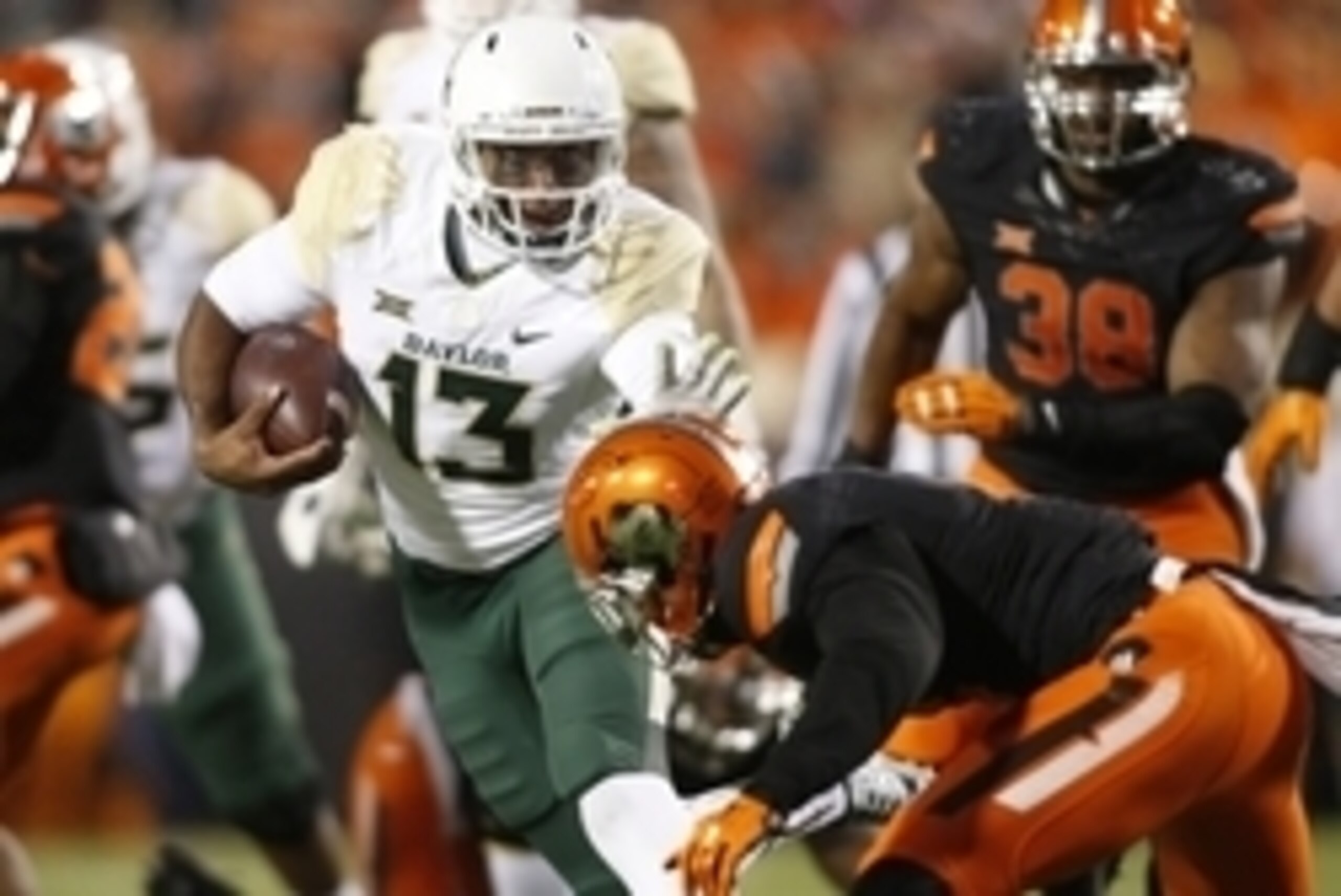Nov 21, 2015; Stillwater, OK, USA; Baylor Bears quarterback Chris Johnson (13) attempts to avoid the tackle of Oklahoma State Cowboys cornerback Ashton Lampkin (6) in the fourth quarter at Boone Pickens Stadium. Baylor won 45-35. Mandatory Credit: Tim Hei