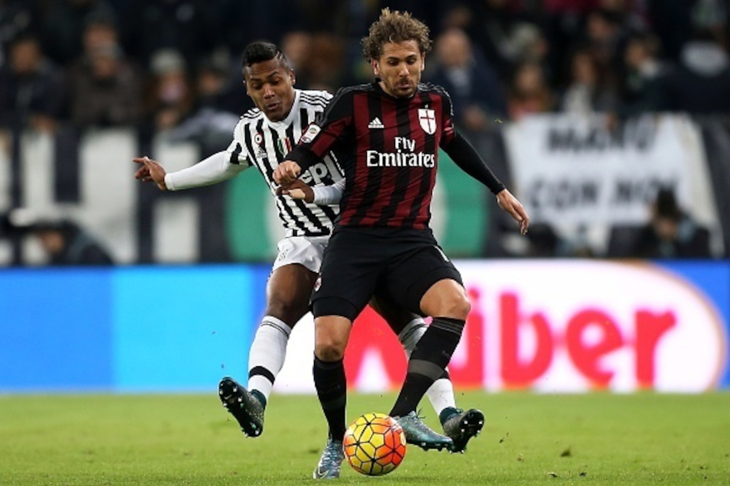 Juventus' defender Brazilian Alex Sandro (L) vies with AC Milan's forward Alessio Cerci during the Italian Serie A  football match Juventus Vs AC Milan on November 21, 2015 at the 'uventus Stadium in Turin.  AFP PHOTO / MARCO BERTORELLO        (Photo cred
