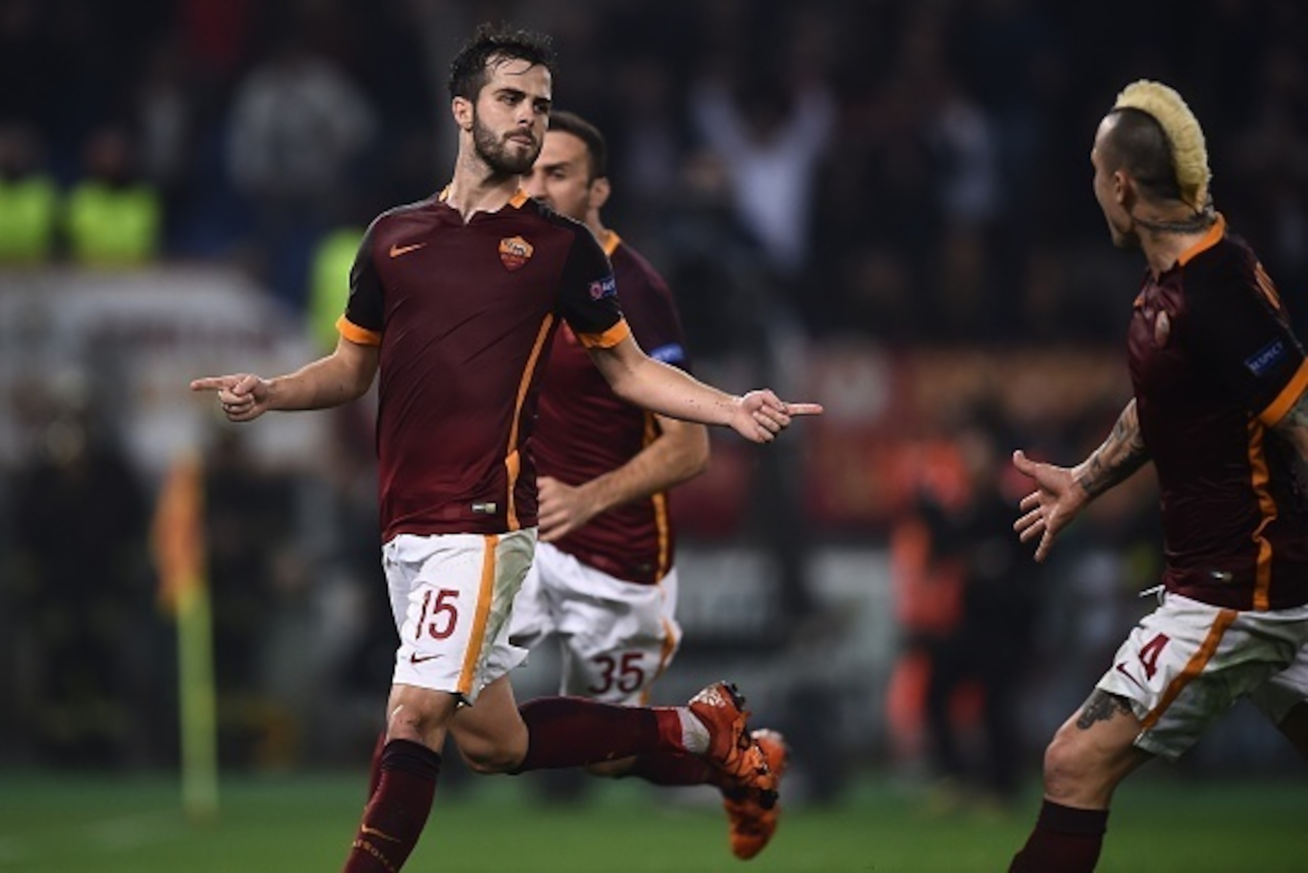 Roma's midfielder from Bosnia-Herzegovina Miralem Pjanic (L) celebrates with teammates after scoring a penalty during the UEFA Champions League football match AS Roma vs Bayer Leverkusen on November 4, 2015 at the Olympic stadium in Rome.    AFP PHOTO / F