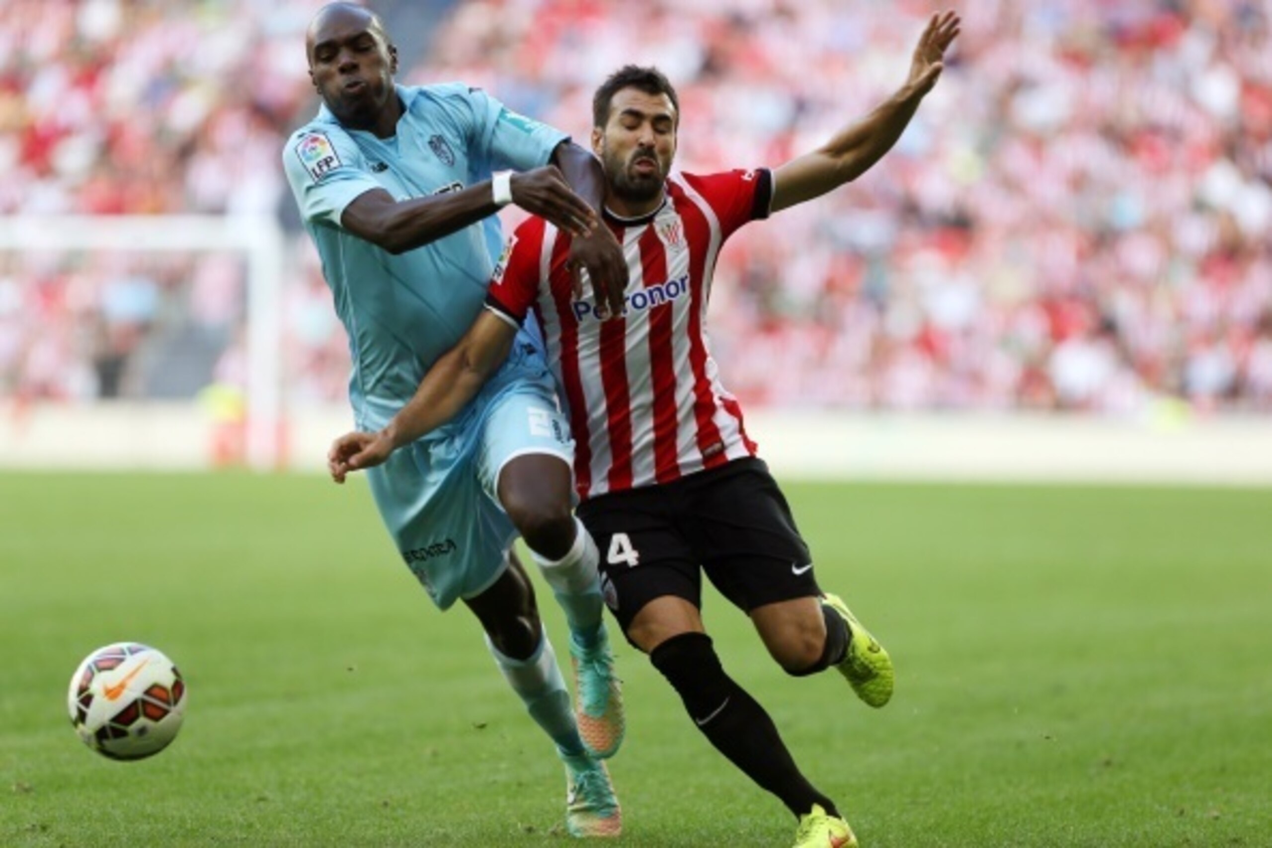 Granada's Cameroonian defender Allan Nyom (L) vies with Athletic Bilbao's defender Mikel Balenziaga during the Spanish league football match Athletic Club Bilbao vs Granada FC at the San Mames stadium in Bilbao on September 20, 2014.   AFP PHOTO/ CESAR MA