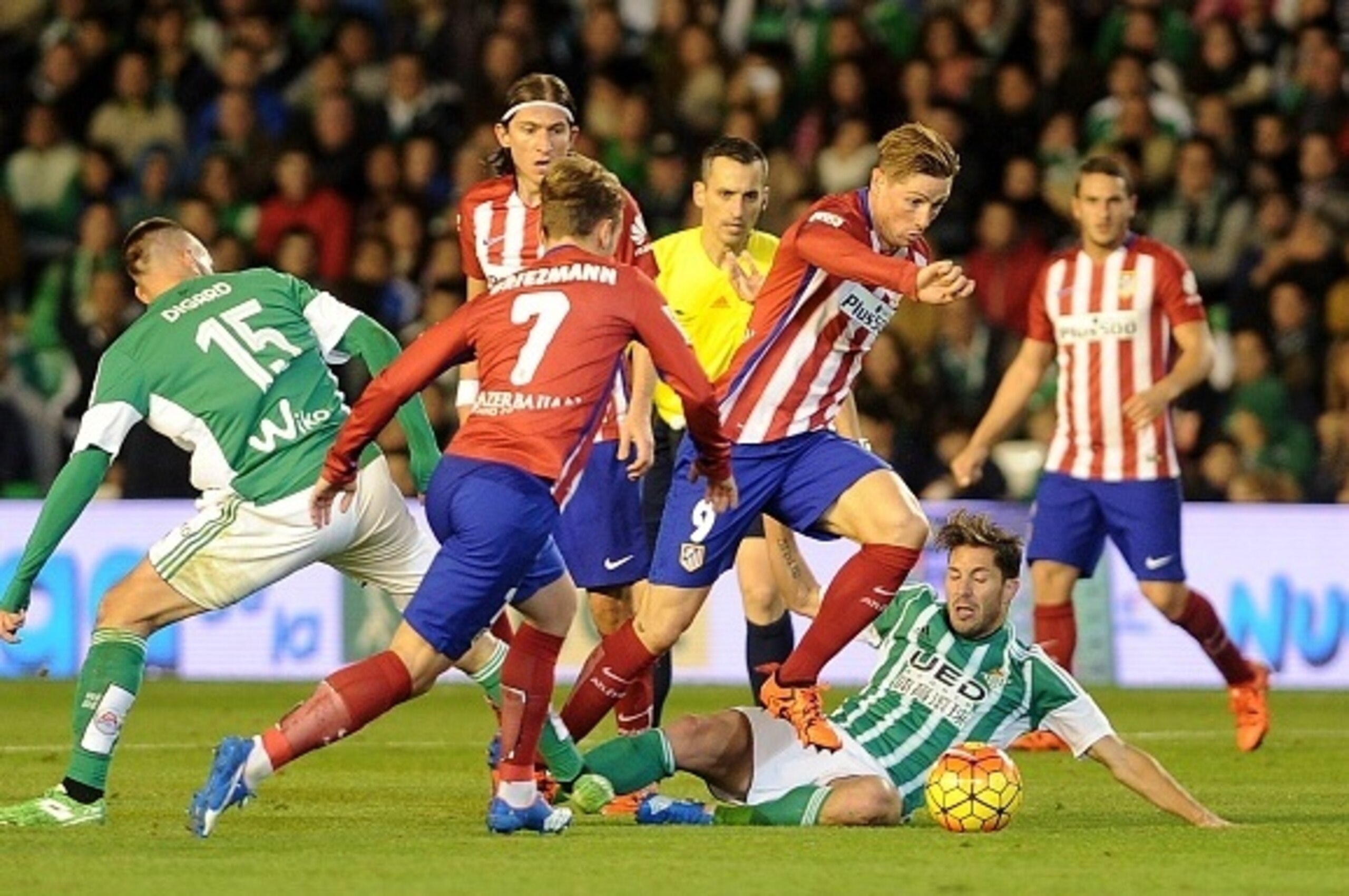 Atletico Madrid's forward Fernando Torres (C) jumps over Betis' defender Alvaro Cejudo (down) during the Spanish league football match Real Betis Balompie vs Club Atletico de Madrid at the Benito Villamarin stadium in Sevilla on November 22, 2015.  AFP PH