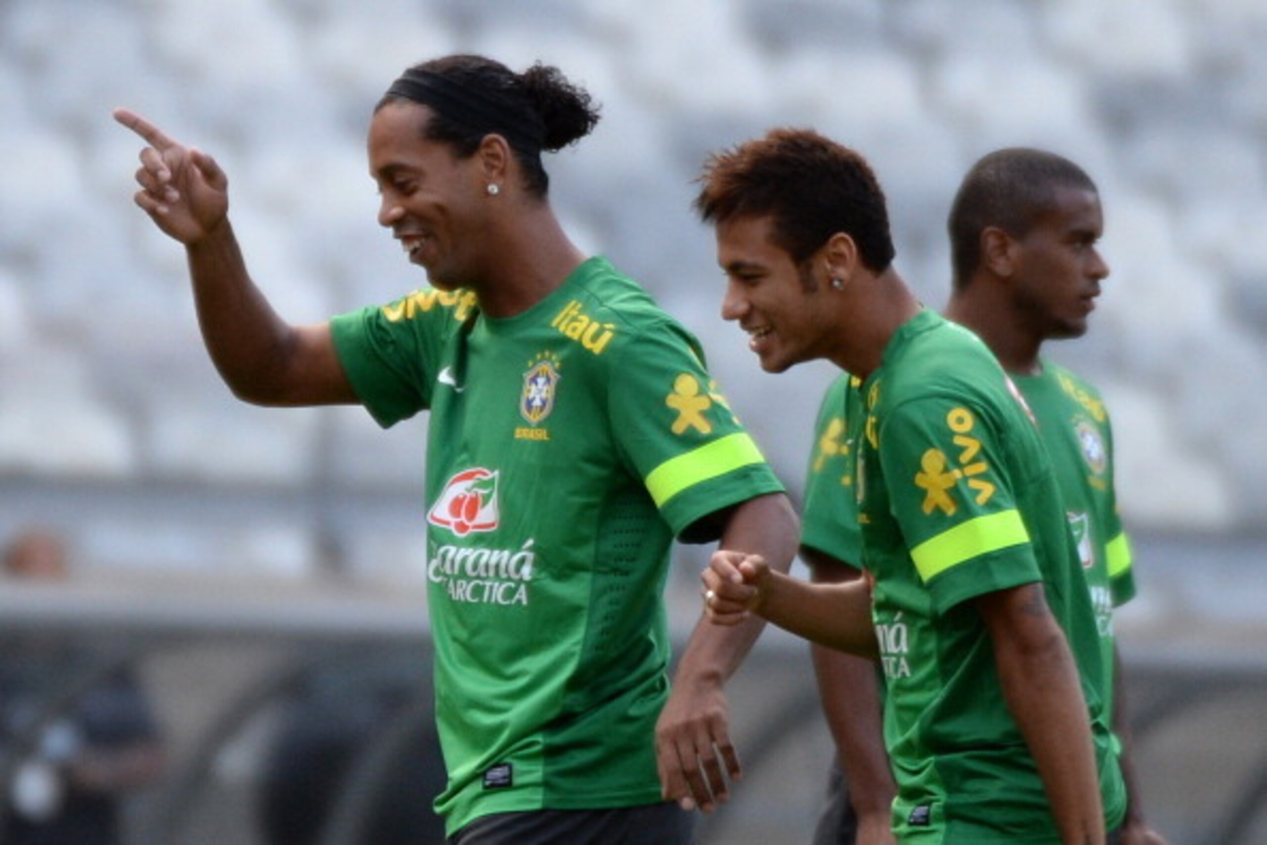 Brazil's Neymar (R) jokes with Ronaldinho Gaucho  during a training session at Mineirao stadium in Belo Horizonte, Minas Gerais, Brazil, on April 23, 2013.  Brazil will play Chile on Wednesday in a friendly match.            AFP PHOTO /VANDERLEI ALMEIDA  
