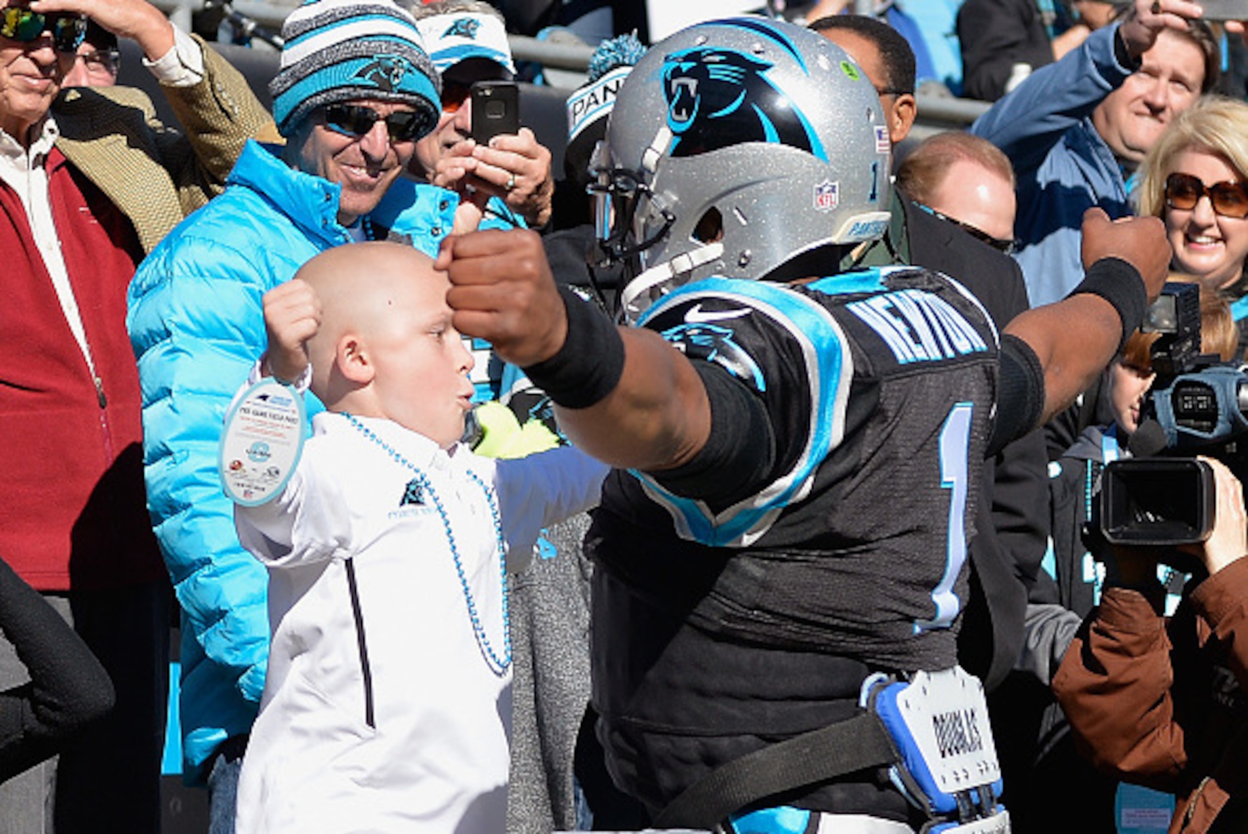 CHARLOTTE, NC - NOVEMBER 22:  Cam Newton #1 of the Carolina Panthers greets a young fan before their game against the Washington Redskins at Bank of America Stadium on November 22, 2015 in Charlotte, North Carolina.  (Photo by Grant Halverson/Getty Images