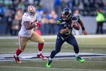 SEATTLE, WA - NOVEMBER 22: Quarterback Russell Wilson #3 of the Seattle Seahawks scrambles out of the pocket as he is chased by linebacker Ahmad Brooks #55 of the San Francisco 49ers during the first half of a game at CenturyLink Field on November 22, 201