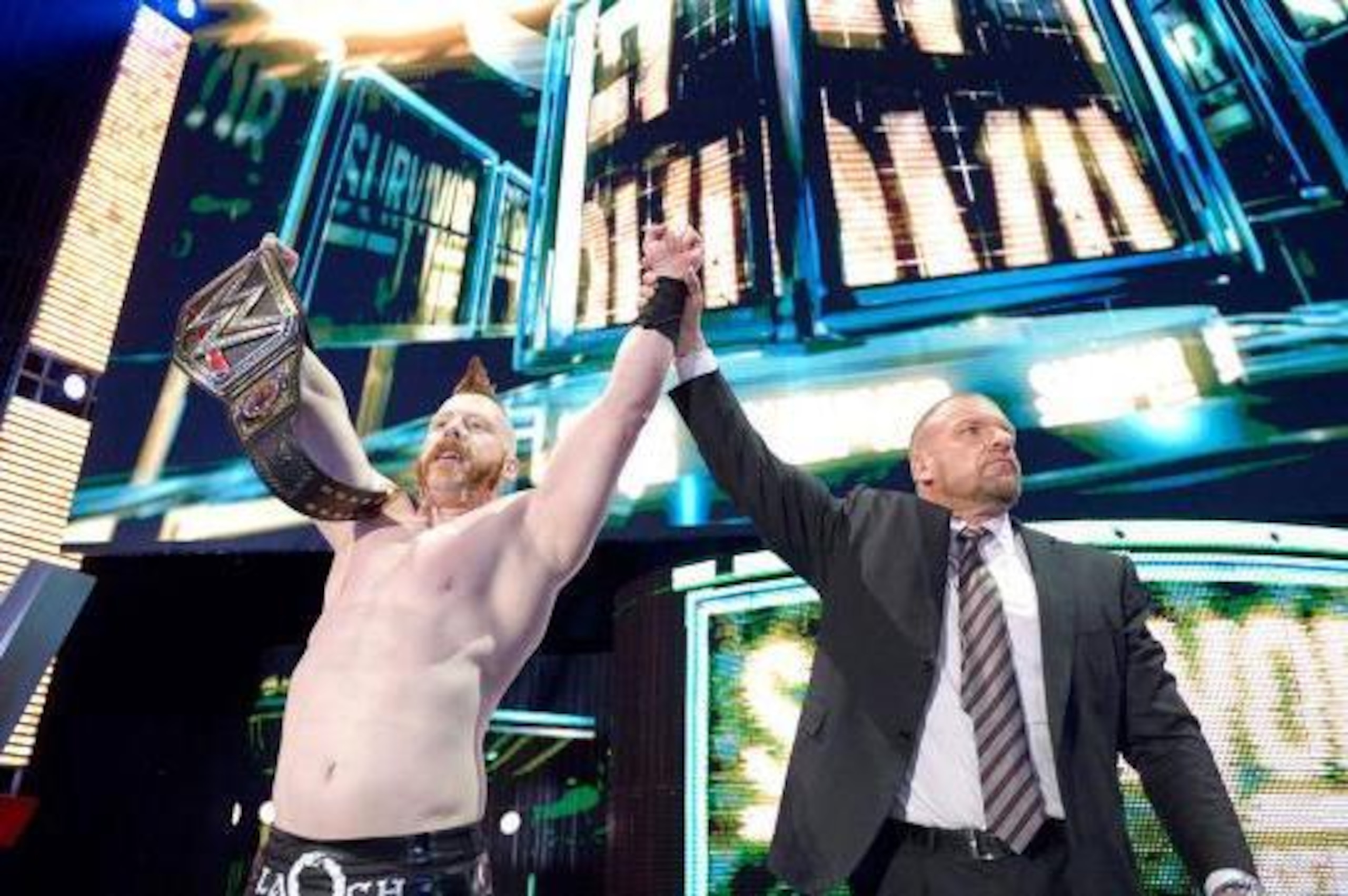 Sheamus celebrates his title win with Triple H.