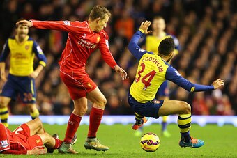 LIVERPOOL, ENGLAND - DECEMBER 21: Lucas Leiva of Liverpool challenges Francis Coquelin of Arsenal during the Barclays Premier League match between Liverpool and Arsenal at Anfield on December 21, 2014 in Liverpool, England.  (Photo by Alex Livesey/Getty I