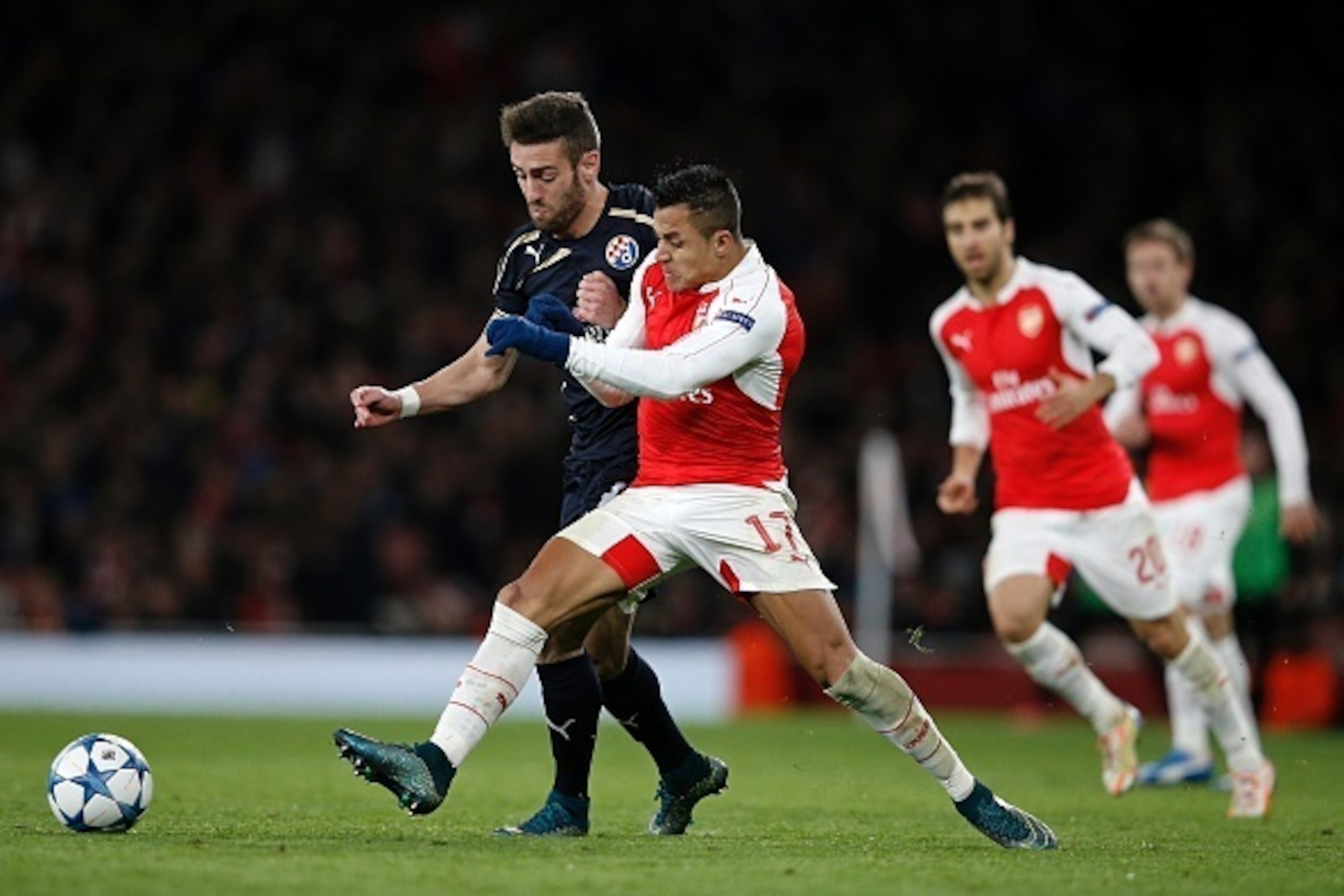 Arsenal's Chilean striker Alexis Sanchez (2nd L) challenges Dinamo Zagreb's defender from Portugal Ivo Daniel Pinto (L) during their UEFA Champions League Group F football match between Arsenal and GNK Dinamo Zagreb at The Emirates Stadium in London on No