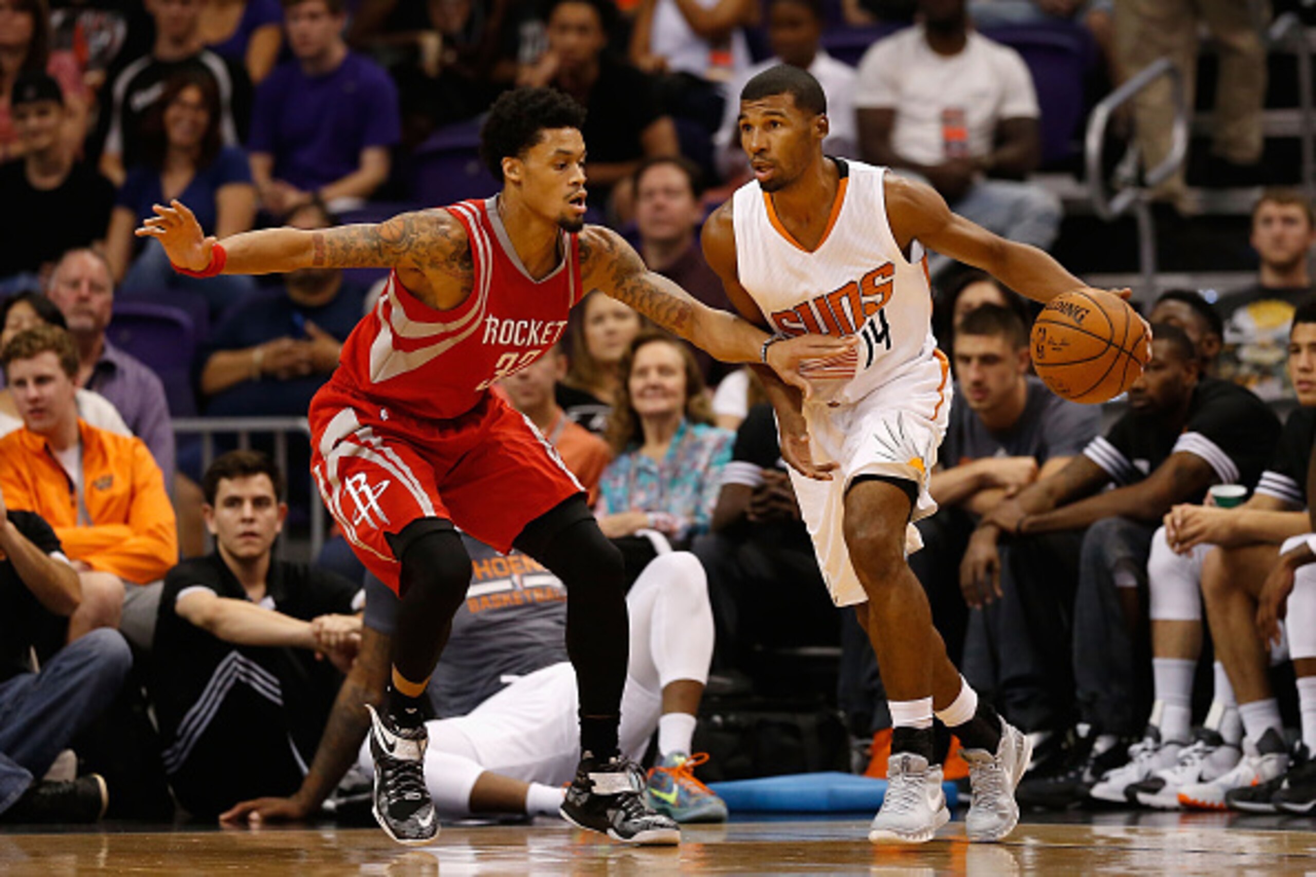 PHOENIX, AZ - OCTOBER 13:  Ronnie Price #14 of the Phoenix Suns handles the ball guarded by K.J. McDaniels #32 of the Houston Rockets during the preseason NBA game at Talking Stick Resort Arena on October 13, 2015 in Phoenix, Arizona. NOTE TO USER: User e