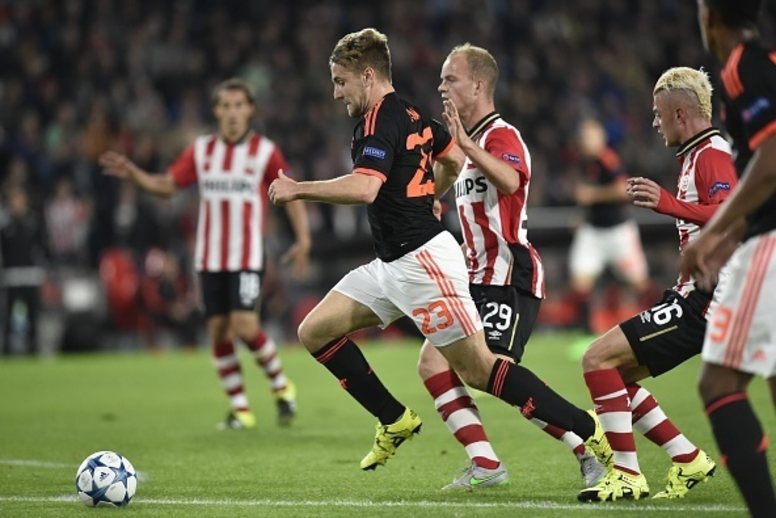 Manchester's Luke Shaw (C) vies with PSV Eindhovens midfielder Jorrit Hendrix (R) during the UEFA Champions League Group B football match between PSV Eindhoven and Manchester United at the Philips stadium in Eindhoven, Belgium on September 15, 2015. AFP P