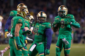 BOSTON, MA - NOVEMBER 21: Sheldon Day #91 of the Notre Dame Fighting Irish celebrates his sack against the Boston College Eagles with his teammates Max Redfield #10, Jaylon Smith #9, and Romeo Okwara #45 at Fenway Park during the 'Shamrock Series' on Nove