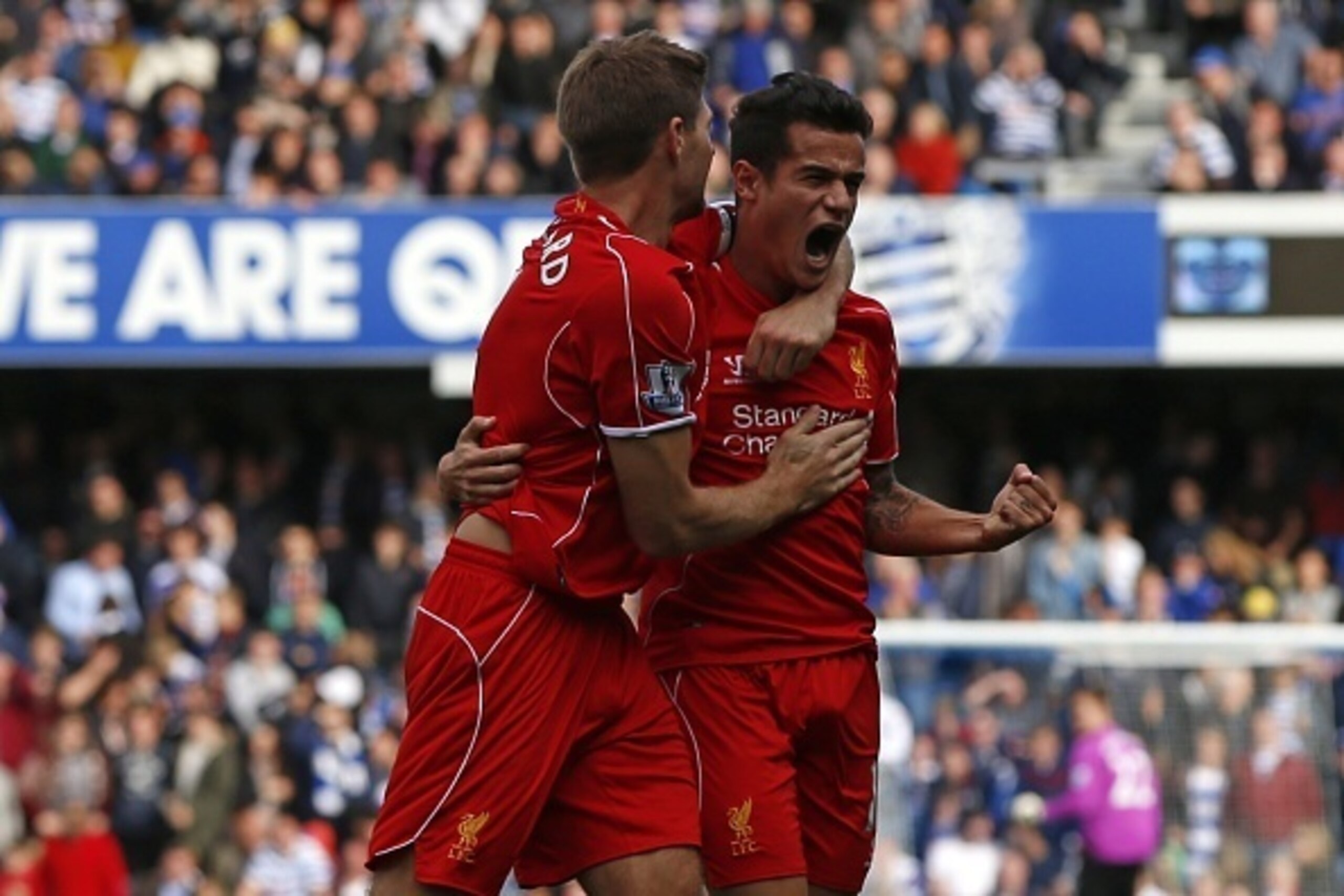 Liverpool's Brazilian midfielder Philippe Coutinho (R) celebrates scoring his goal with Liverpool's English midfielder Steven Gerrard (L) during the English Premier League football match between Queens Park Rangers and Liverpool at Loftus Road in London o