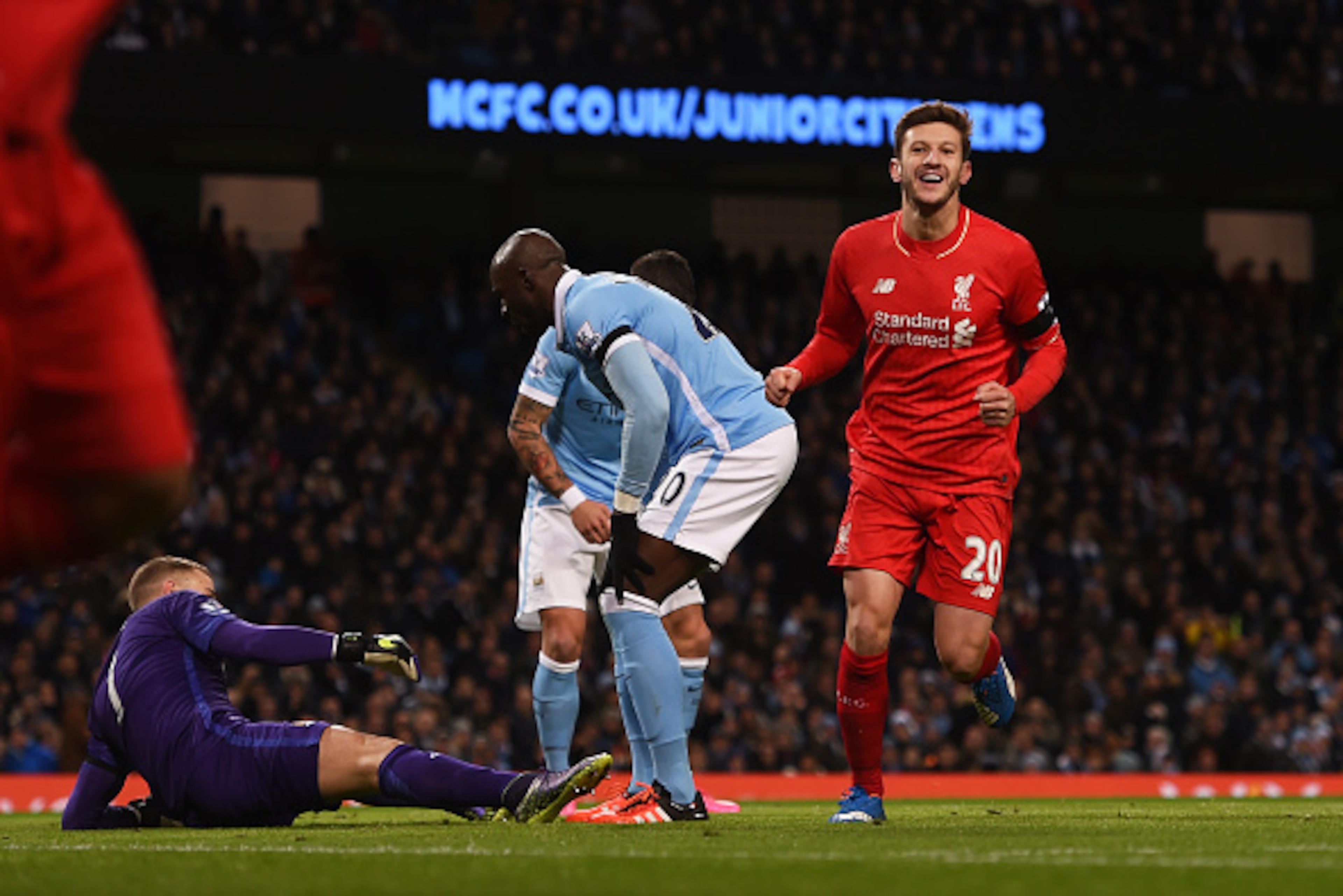 MANCHESTER, ENGLAND - NOVEMBER 21:  Adam Lallana (1st R) of Liverpool celebrates his team's first goal scored by Eliaquim Mangala (2nd R) of Manchester City during the Barclays Premier League match between Manchester City and Liverpool at Etihad Stadium o